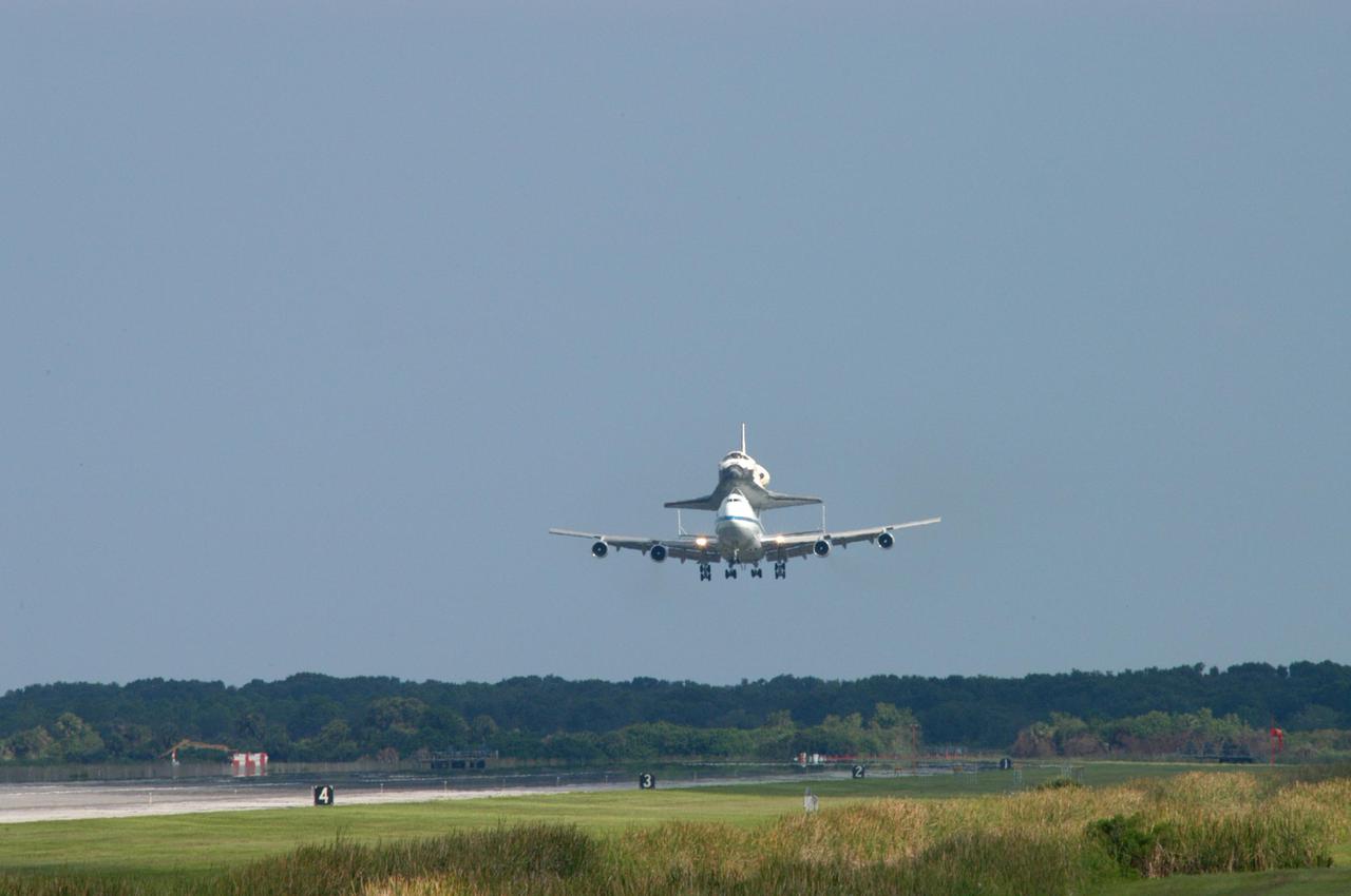 KENNEDY SPACE CENTER, FLA. -  Space Shuttle Discovery, atop a modified Boeing 747 Shuttle Carrier Aircraft (SCA), is on its final approach to land on runway 15 at NASA Kennedy Space Center's Shuttle Landing Facility (SLF) at about 10:00 a.m. EDT. The cross-country ferry flight became necessary when two days of unfavorable weather conditions at KSC forced Discovery to land on runway 22 at Edwards Air Force Base, Calif., on Aug. 9 following mission STS-114. On the return trip, stops were made at Altus Air Force Base, Okla., and Barksdale Air Force Base, La., where Discovery stayed for two nights.  The SCA and Discovery will be towed to the Mate_Demate Device at the SLF where a crane will lift Discovery from the SCA and place it on solid ground. Discovery will then be towed to the Orbiter Processing Facility where preparations will begin for its next flight, STS-121.