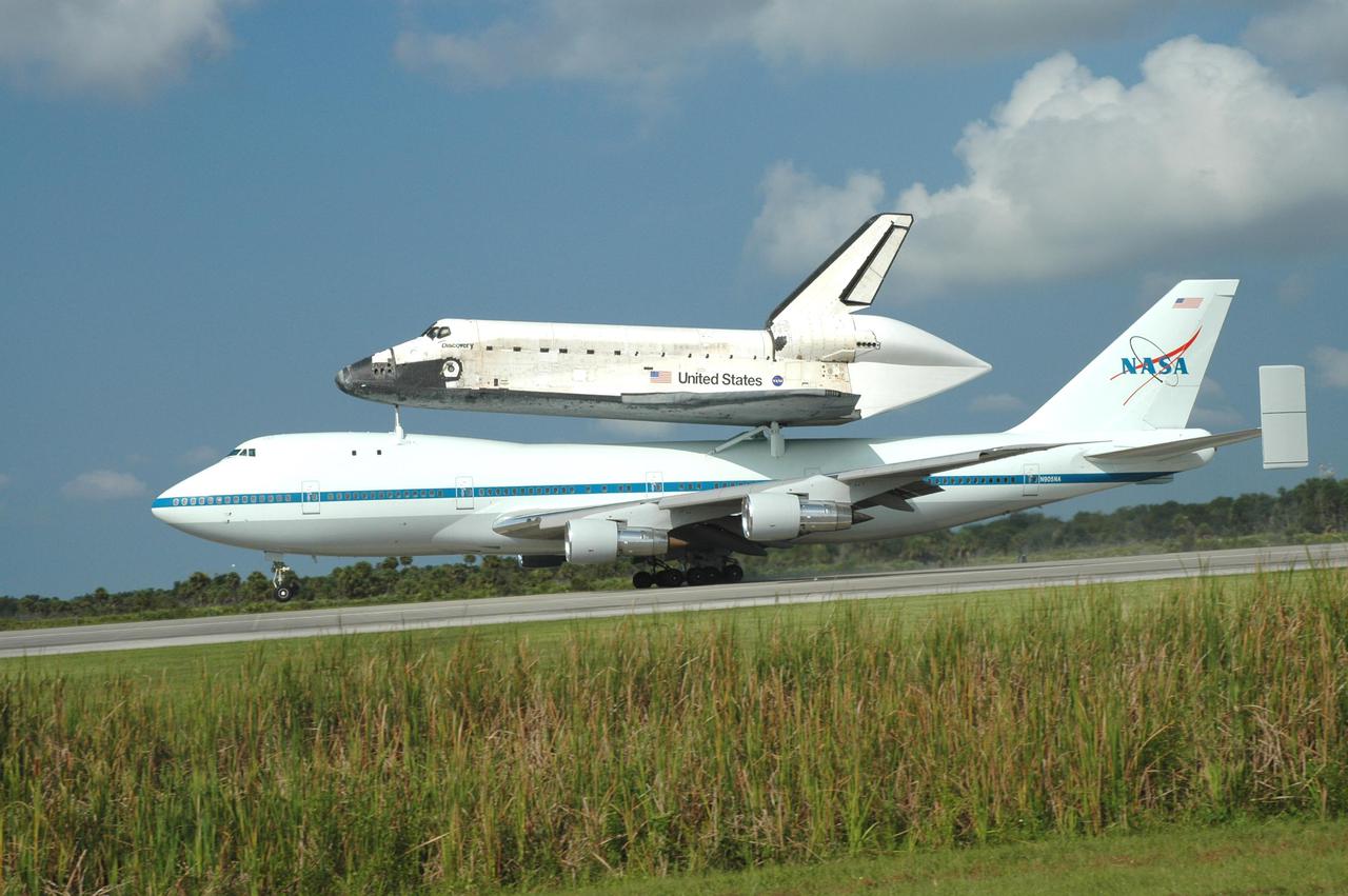 KENNEDY SPACE CENTER, FLA. -  Space Shuttle Discovery, atop a modified Boeing 747 Shuttle Carrier Aircraft (SCA),  touches down on runway 15 at NASA Kennedy Space Center's Shuttle Landing Facility (SLF) at about 10:00 a.m. EDT. The cross-country ferry flight became necessary when two days of unfavorable weather conditions at KSC forced Discovery to land on runway 22 at Edwards Air Force Base, Calif., on Aug. 9 following mission STS-114. On the return trip, stops were made at Altus Air Force Base, Okla., and Barksdale Air Force Base, La., where Discovery stayed for two nights.  The SCA and Discovery will be towed to the Mate_Demate Device at the SLF where a crane will lift Discovery from the SCA and place it on solid ground. Discovery will then be towed to the Orbiter Processing Facility where preparations will begin for its next flight, STS-121.