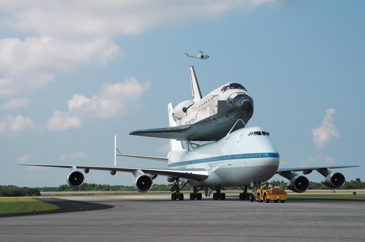 KENNEDY SPACE CENTER, FLA. -  Space Shuttle Discovery, atop a modified Boeing 747 Shuttle Carrier Aircraft (SCA), is towed to the Mate_Demate Device (MDD) at NASA Kennedy Space Center's Shuttle Landing Facility (SLF) following touchdown on runway 15 at about 10:00 a.m. EDT. The cross-country ferry flight became necessary when two days of unfavorable weather conditions at KSC forced Discovery to land on runway 22 at Edwards Air Force Base, Calif., on Aug. 9 following mission STS-114. On the return trip, stops were made at Altus Air Force Base, Okla., and Barksdale Air Force Base, La., where Discovery stayed for two nights. A crane on the MDD will lift Discovery from the SCA and place it on solid ground. Discovery will then be towed to the Orbiter Processing Facility where preparations will begin for its next flight, STS-121.