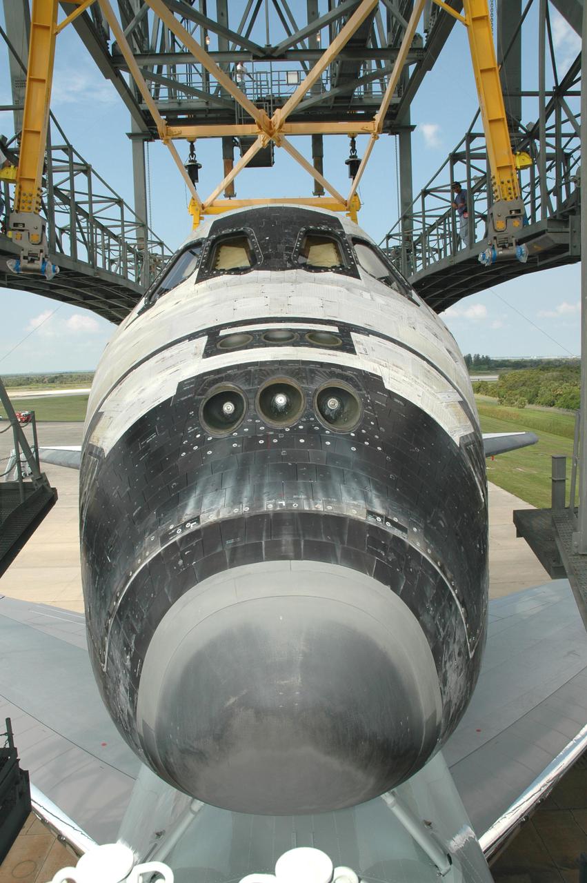 KENNEDY SPACE CENTER, FLA. - This view shows the orbiter Discovery on top of the Shuttle Carrier Aircraft, a modified Boeing 747, being towed into the mate_demate device at NASA Kennedy Space Center’s Shuttle Landing Facility. Discovery was returned to Kennedy Space Center on a ferry flight from Edwards Air Force Base in California, where it landed Aug. 9 after 13 days in space on mission STS-114. In the mate_demate device, a horizontal structure mounted at the 80-foot level between two towers controls and guides a large lift beam that attaches to the orbiter to raise and lower it. Once Discovery is lifted off the back of the SCA, the 747 can then roll away and the orbiter will be lowered to the ground. It will then be towed from the SLF to the Orbiter Processing Facility. Once inside the OPF, the payload bay doors will be opened and the MPLM Raffaello brought back from the International Space Station will be unloaded and transferred to the Space Station Processing Facility. This concludes mission STS-114.