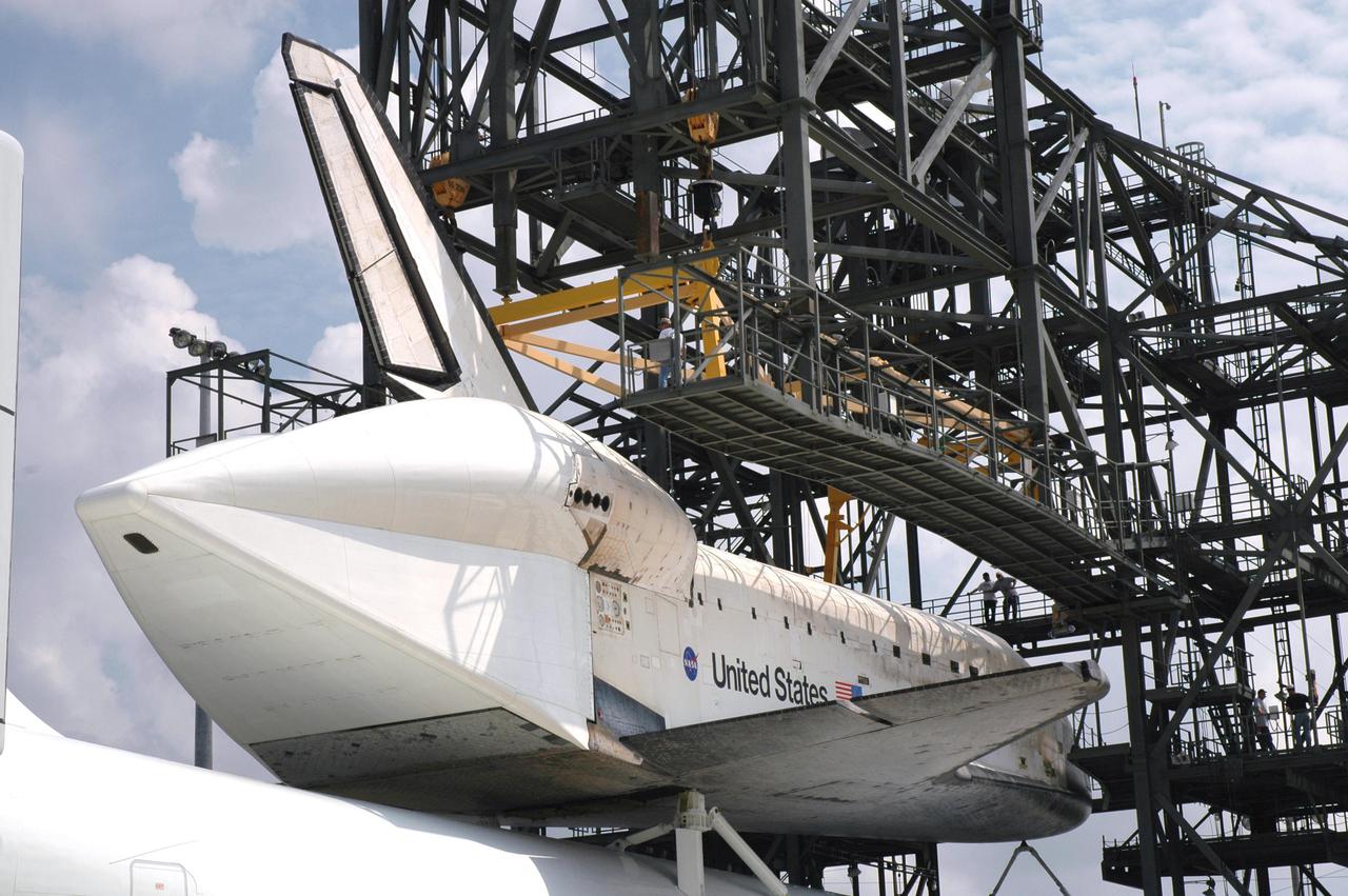 KENNEDY SPACE CENTER, FLA. - The orbiter Discovery on top of the Shuttle Carrier Aircraft, a modified Boeing 747, is towed into the mate_demate device at NASA Kennedy Space Center’s Shuttle Landing Facility. Visible in the closeup is the tail cone that covers the main engines during the ferry flight. Discovery was returned to Kennedy Space Center on a ferry flight from Edwards Air Force Base in California, where it landed Aug. 9 after 13 days in space on mission STS-114. In the mate_demate device, a horizontal structure mounted at the 80-foot level between two towers controls and guides a large lift beam that attaches to the orbiter to raise and lower it. Once Discovery is lifted off the back of the SCA, the 747 can then roll away and the orbiter will be lowered to the ground. It will then be towed from the SLF to the Orbiter Processing Facility. Once inside the OPF, the payload bay doors will be opened and the MPLM Raffaello brought back from the International Space Station will be unloaded and transferred to the Space Station Processing Facility. This concludes mission STS-114.
