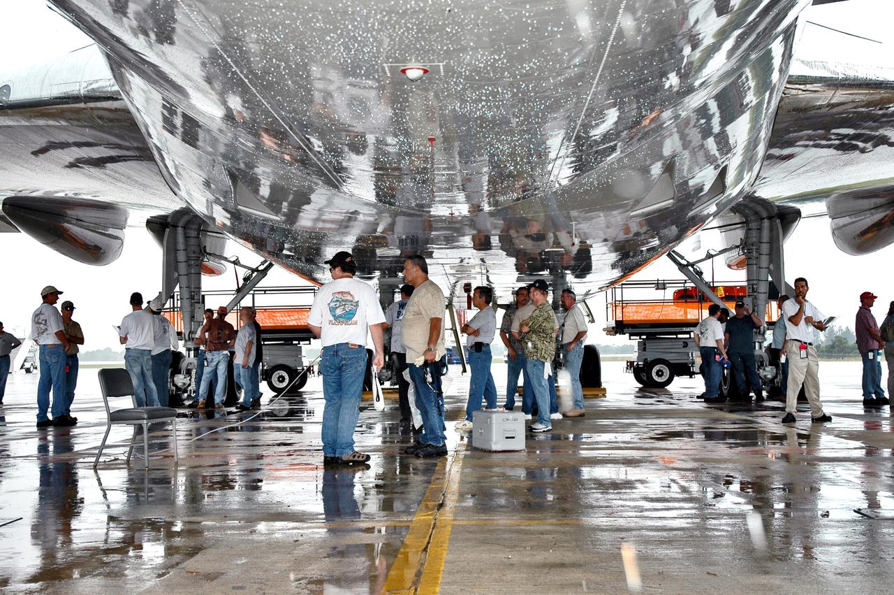 KENNEDY SPACE CENTER, FLA. -  At NASA Kennedy Space Center’s Shuttle Landing Facility, workers secure the Shuttle Carrier Aircraft, a modified Boeing 747, on the ground under the mate_demate device.  The orbiter Discovery is still on top of the aircraft.  Discovery was returned to Kennedy Space Center on a ferry flight from Edwards Air Force Base in California, where it landed Aug. 9 after 13 days in space on mission STS-114.  In the mate_demate device, a horizontal structure mounted at the 80-foot level between two towers controls and guides a large lift beam that attaches to the orbiter to raise and lower it.  Once Discovery is lifted off the back of the SCA, the 747 can then roll away and the orbiter will be lowered to the ground.  It will then be towed from the SLF to the Orbiter Processing Facility.  Once inside the OPF, the payload bay doors will be opened and the MPLM Raffaello brought back from the International Space Station will be unloaded and transferred to the Space Station Processing Facility.  This concludes mission STS-114.