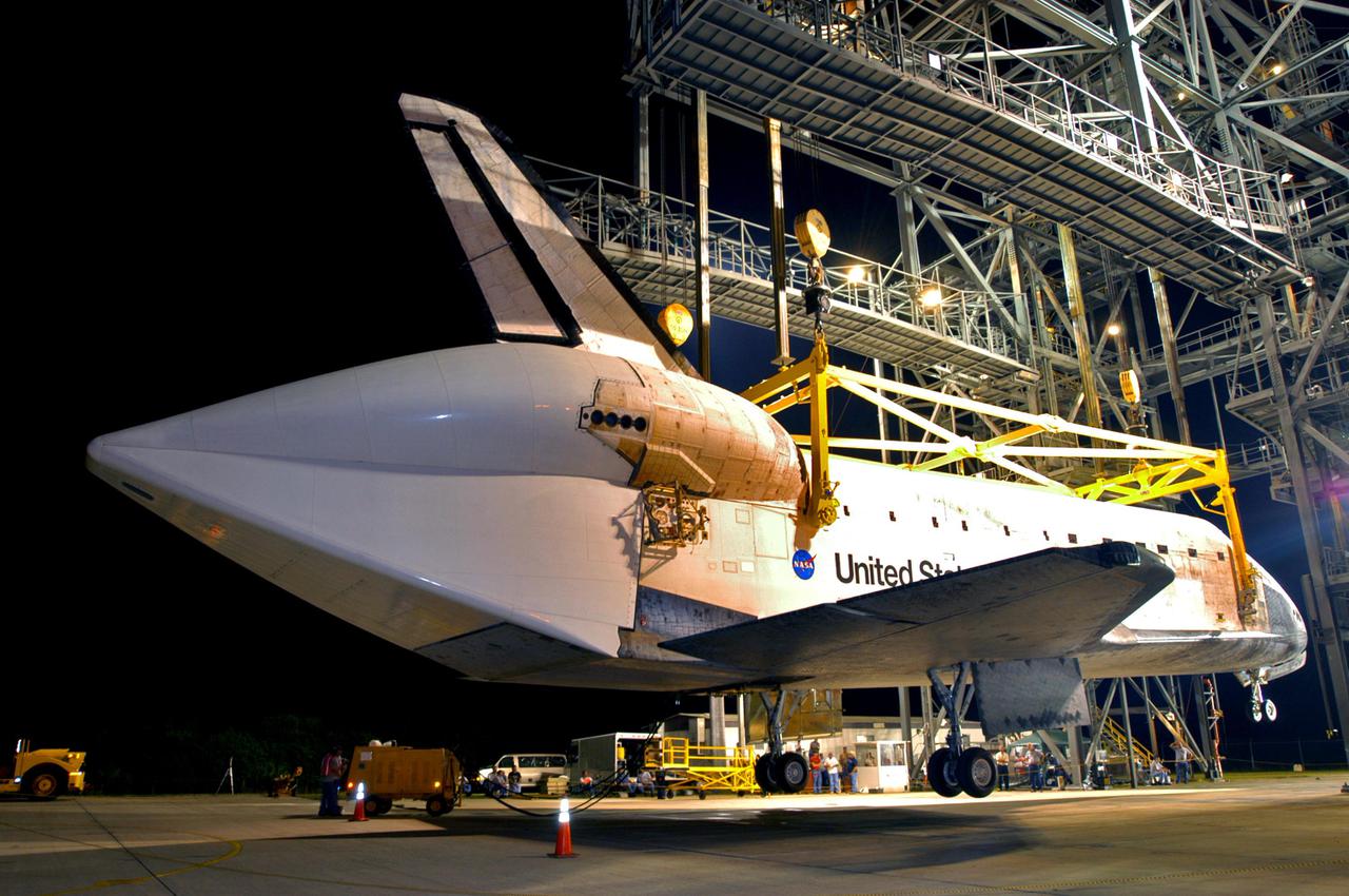 KENNEDY SPACE CENTER, FLA. - After being lowered close enough to the ground from the mate_demate device, Discovery’s wheels are lowered at NASA Kennedy Space Center’s Shuttle Landing Facility.  Visible on the orbiter is the tail cone that covers the main engines during the ferry flight.   Discovery was returned to Kennedy Space Center on a ferry flight from Edwards Air Force Base in California, where it landed Aug. 9 after 13 days in space on mission STS-114.  In the mate_demate device, a horizontal structure mounted at the 80-foot level between two towers controls and guides a large lift beam that attaches to the orbiter to raise and lower it.  The orbiter will be lowered to the ground and then be towed to the Orbiter Processing Facility.  Once inside the OPF, the payload bay doors will be opened and the MPLM Raffaello brought back from the International Space Station will be unloaded and transferred to the Space Station Processing Facility.  This concludes mission STS-114.