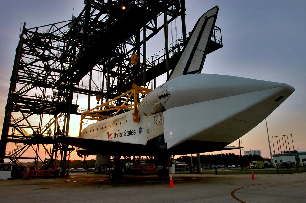 KENNEDY SPACE CENTER, FLA. - Just before sunrise, Discovery finally rests on its wheels on the ground at NASA Kennedy Space Center’s Shuttle Landing Facility.  The orbiter was lowered overnight from the mate_demate device after the Shuttle Carrier Aircraft, a modified Boeing 747, was rolled away.  Discovery was returned to Kennedy Space Center on a ferry flight from Edwards Air Force Base in California, where it landed Aug. 9 after 13 days in space on mission STS-114.  In the mate_demate device, a horizontal structure mounted at the 80-foot level between two towers controls and guides a large lift beam that attaches to the orbiter to raise and lower it.  The orbiter will be lowered to the ground and then be towed to the Orbiter Processing Facility.  Once inside the OPF, the payload bay doors will be opened and the MPLM Raffaello brought back from the International Space Station will be unloaded and transferred to the Space Station Processing Facility.  This concludes mission STS-114.