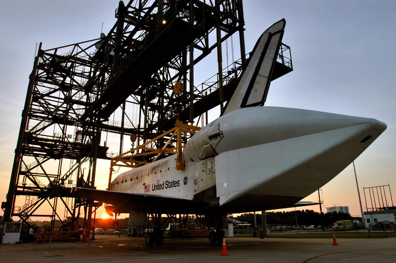 KENNEDY SPACE CENTER, FLA. - At sunrise, Discovery finally rests on its wheels on the ground at NASA Kennedy Space Center’s Shuttle Landing Facility.  The orbiter was lowered overnight from the mate_demate device after the Shuttle Carrier Aircraft, a modified Boeing 747, was rolled away.   Discovery was returned to Kennedy Space Center on a ferry flight from Edwards Air Force Base in California, where it landed Aug. 9 after 13 days in space on mission STS-114.  In the mate_demate device, a horizontal structure mounted at the 80-foot level between two towers controls and guides a large lift beam that attaches to the orbiter to raise and lower it.  The orbiter will be towed to the Orbiter Processing Facility.  Once inside the OPF, the payload bay doors will be opened and the MPLM Raffaello brought back from the International Space Station will be unloaded and transferred to the Space Station Processing Facility.  This concludes mission STS-114.