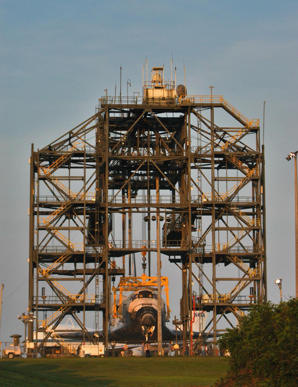 KENNEDY SPACE CENTER, FLA. - Discovery finally rests on its wheels on the ground at NASA Kennedy Space Center’s Shuttle Landing Facility.  The orbiter was lowered overnight from the mate_demate device after the Shuttle Carrier Aircraft, a modified Boeing 747, was rolled away.  Discovery was returned to Kennedy Space Center on a ferry flight from Edwards Air Force Base in California, where it landed Aug. 9 after 13 days in space on mission STS-114.  In the mate_demate device, a horizontal structure mounted at the 80-foot level between two towers controls and guides a large lift beam that attaches to the orbiter to raise and lower it.  The orbiter will be towed to the Orbiter Processing Facility.  Once inside the OPF, the payload bay doors will be opened and the MPLM Raffaello brought back from the International Space Station will be unloaded and transferred to the Space Station Processing Facility.  This concludes mission STS-114.