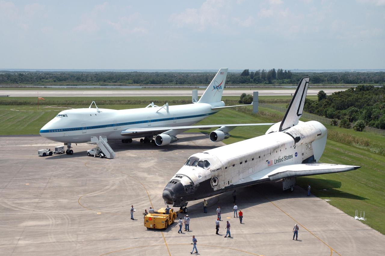 KENNEDY SPACE CENTER, FLA. - Discovery is pushed from the mate_demate device on NASA Kennedy Space Center’s Shuttle Landing Facility. Discovery was returned to NASA Kennedy Space Center on a ferry flight atop the Shuttle Carrier Aircraft (SCA) from Edwards Air Force Base in California, arriving Aug. 21. The SCA is in the background. Discovery will be towed to the Orbiter Processing Facility where the Multi-Purpose Logistics Module Raffaello still inside will be removed from the payload bay and transferred to the Space Station Processing Facility. The orbiter will then begin processing for the second Return to Flight mission, STS-121, scheduled for launch no earlier than March 2006.