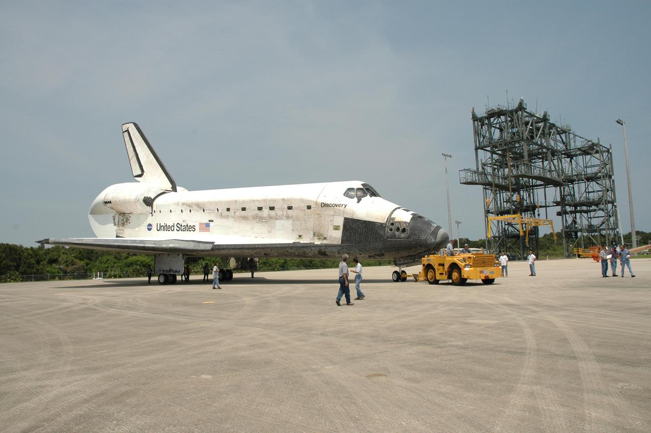 KENNEDY SPACE CENTER, FLA. - A tow vehicle maneuvers Discovery on NASA Kennedy Space Center’s Shuttle Landing Facility into a position for towing. Discovery was returned to NASA Kennedy Space Center on a ferry flight atop the Shuttle Carrier Aircraft (SCA) from Edwards Air Force Base in California, arriving Aug. 21. Discovery will be towed to the Orbiter Processing Facility where the Multi-Purpose Logistics Module Raffaello still inside will be removed from the payload bay and transferred to the Space Station Processing Facility. The orbiter will then begin processing for the second Return to Flight mission, STS-121, scheduled for launch no earlier than March 2006.