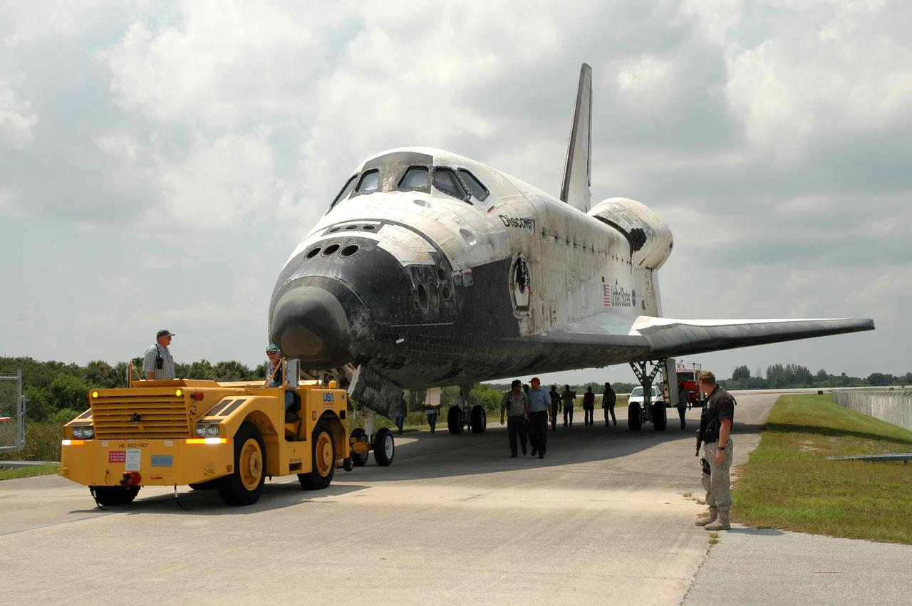 KENNEDY SPACE CENTER, FLA. - A tow vehicle begins moving Discovery away from NASA Kennedy Space Center’s Shuttle Landing Facility. Discovery was returned to NASA Kennedy Space Center on a ferry flight atop the Shuttle Carrier Aircraft (SCA) from Edwards Air Force Base in California, arriving Aug. 21. Discovery will be towed to the Orbiter Processing Facility where the Multi-Purpose Logistics Module Raffaello still inside will be removed from the payload bay and transferred to the Space Station Processing Facility. The orbiter will then begin processing for the second Return to Flight mission, STS-121, scheduled for launch no earlier than March 2006.