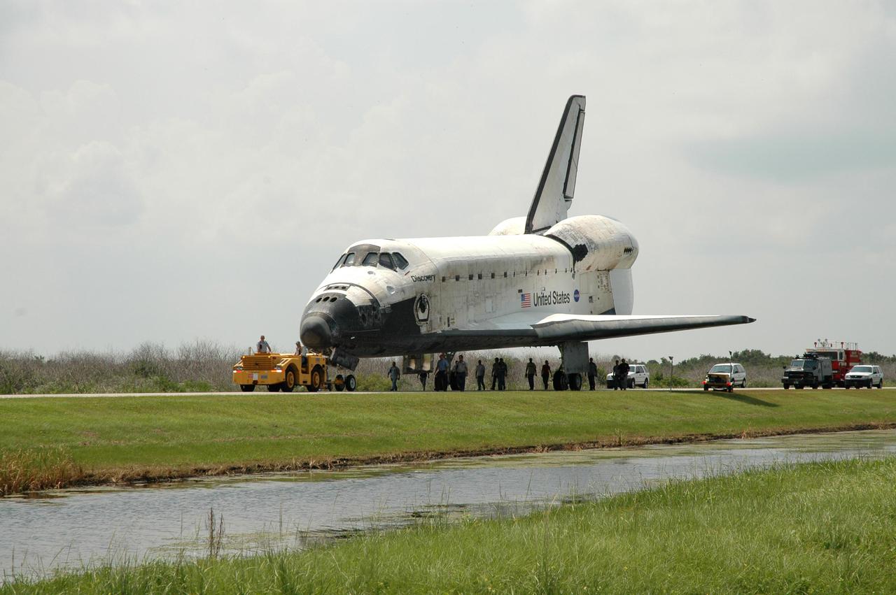 KENNEDY SPACE CENTER, FLA. - Discovery is towed along the tow-way from NASA Kennedy Space Center’s Shuttle Landing Facility to the Orbiter Processing Facility. Discovery was returned to NASA Kennedy Space Center on a ferry flight atop the Shuttle Carrier Aircraft (SCA) from Edwards Air Force Base in California, arriving Aug. 21. Discovery will be towed to the Orbiter Processing Facility where the Multi-Purpose Logistics Module Raffaello still inside will be removed from the payload bay and transferred to the Space Station Processing Facility. The orbiter will then begin processing for the second Return to Flight mission, STS-121, scheduled for launch no earlier than March 2006.