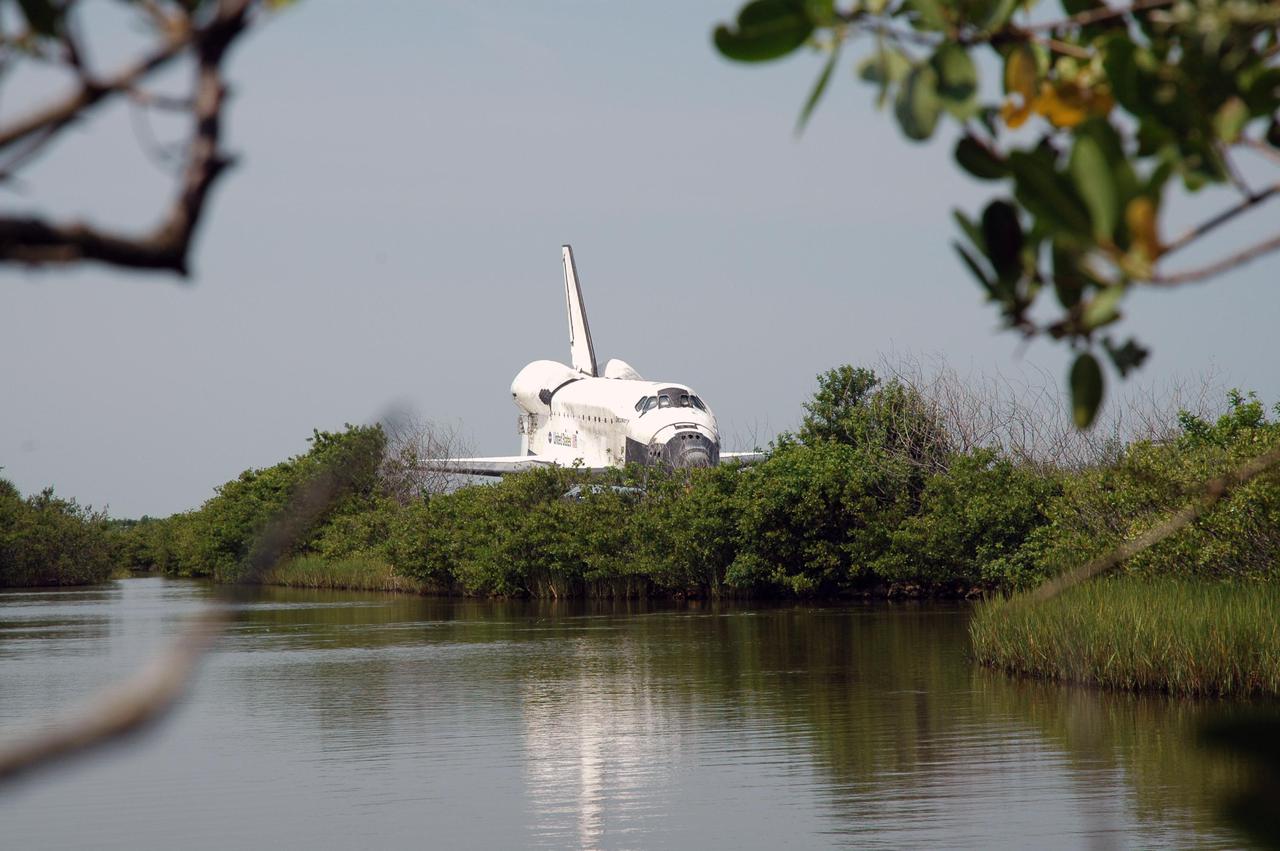 KENNEDY SPACE CENTER, FLA. - Discovery is viewed across Banana Creek as the orbiter is towed along the tow-way from NASA Kennedy Space Center’s Shuttle Landing Facility to the Orbiter Processing Facility. Discovery was returned to NASA Kennedy Space Center on a ferry flight atop the Shuttle Carrier Aircraft (SCA) from Edwards Air Force Base in California, arriving Aug. 21. Discovery will be towed to the Orbiter Processing Facility where the Multi-Purpose Logistics Module Raffaello still inside will be removed from the payload bay and transferred to the Space Station Processing Facility. The orbiter will then begin processing for the second Return to Flight mission, STS-121, scheduled for launch no earlier than March 2006.