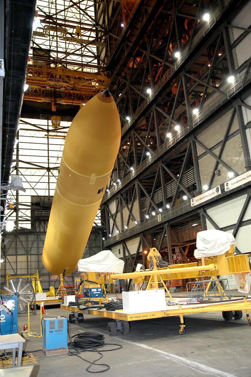 KENNEDY SPACE CENTER, FLA. - Inside NASA Kennedy Space Center’s Vehicle Assembly Building, External Tank 119 is lowered to a horizontal position. Then it will be placed on a transporter in the transfer aisle to be moved to the barge at the Turn Basin. The tank will embark on a voyage around the Florida peninsula to the Michoud Assembly Facility in New Orleans. Delivered to KSC in June, ET-119 is the third newly redesigned tank.