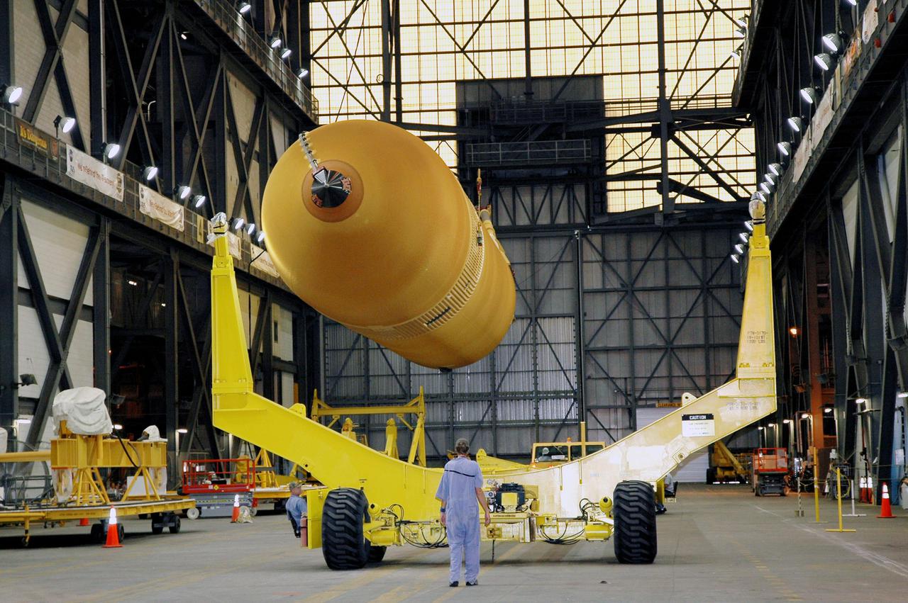 KENNEDY SPACE CENTER, FLA. - Inside NASA Kennedy Space Center’s Vehicle Assembly Building, External Tank 119 is lowered onto a transporter in the transfer aisle to be moved to the barge at the Turn Basin. The tank will embark on a voyage around the Florida peninsula to the Michoud Assembly Facility in New Orleans. Delivered to KSC in June, ET-119 is the third newly redesigned tank.
