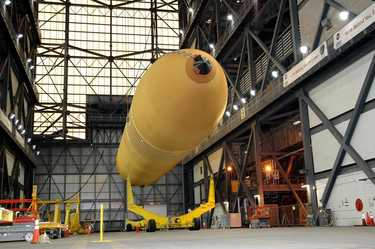KENNEDY SPACE CENTER, FLA. - Inside NASA Kennedy Space Center’s Vehicle Assembly Building, External Tank 119 is lowered onto a transporter in the transfer aisle to be moved to the barge at the Turn Basin. The tank will embark on a voyage around the Florida peninsula to the Michoud Assembly Facility in New Orleans. Delivered to KSC in June, ET-119 is the third newly redesigned tank.