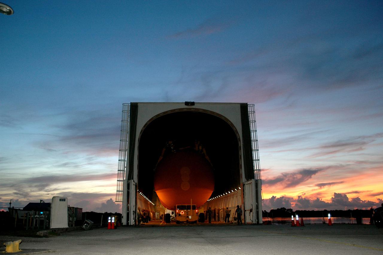 KENNEDY SPACE CENTER, FLA.  -   Under pre-dawn skies of blue and red, External Tank 119 is loaded onto the barge at the Turn Basin.  The tank will embark on a voyage around the Florida peninsula  to the Michoud Assembly Facility in New Orleans.  Delivered to KSC in June, ET-119 is the third newly redesigned tank.