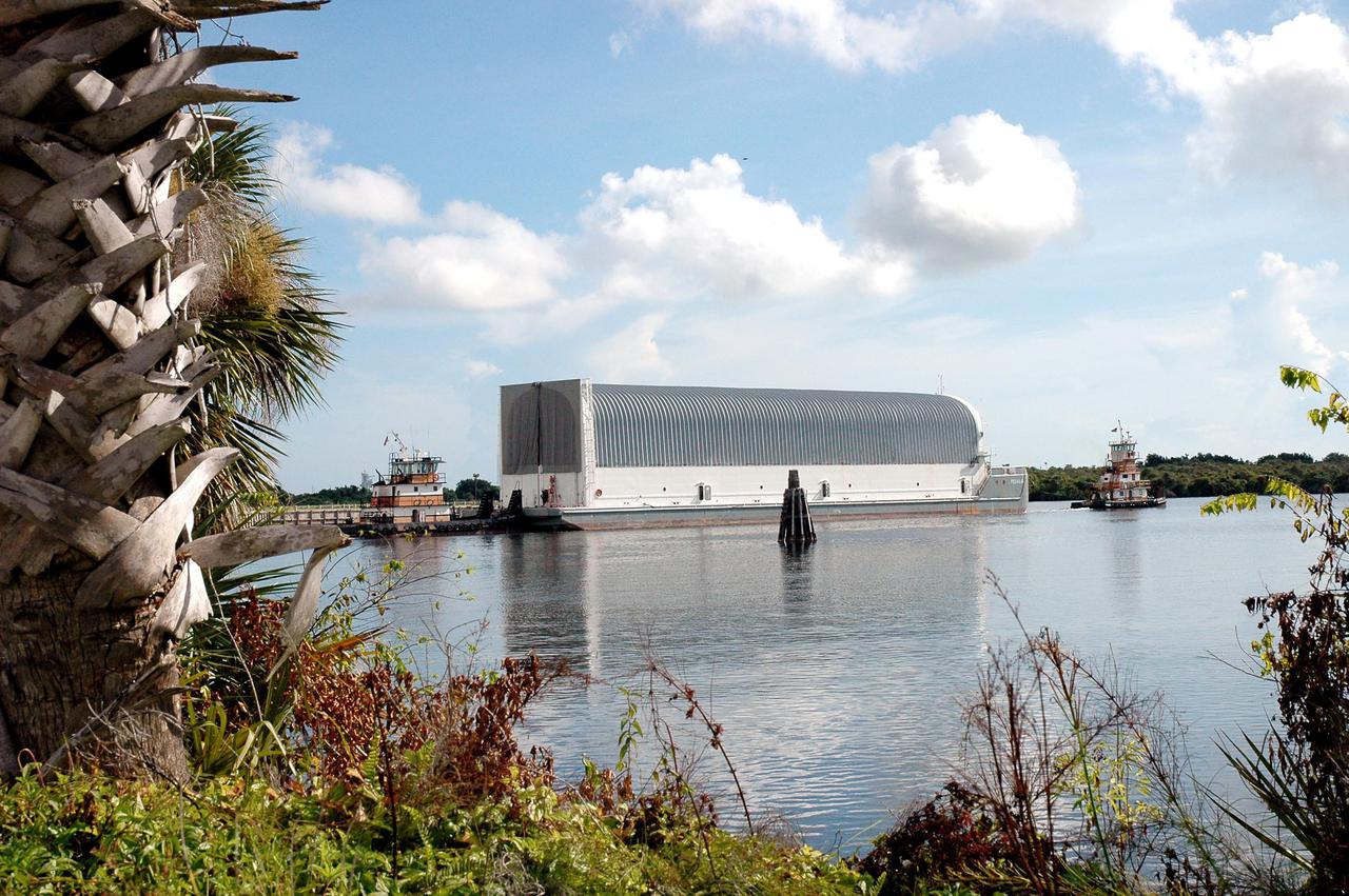 KENNEDY SPACE CENTER, FLA. - Viewed across the Turn Basin at NASA Kennedy Space Center, the barge Pegasus is towed away from the dock on the other side. It is being towed to Port Canaveral where it will join one of the Solid Rocket Booster Recovery Ships and begin its journey around the Florida peninsula to Michoud Assembly Facility in New Orleans. The barge’s cargo is External Tank 119. Delivered to KSC in June, ET-119 is the third newly redesigned tank.