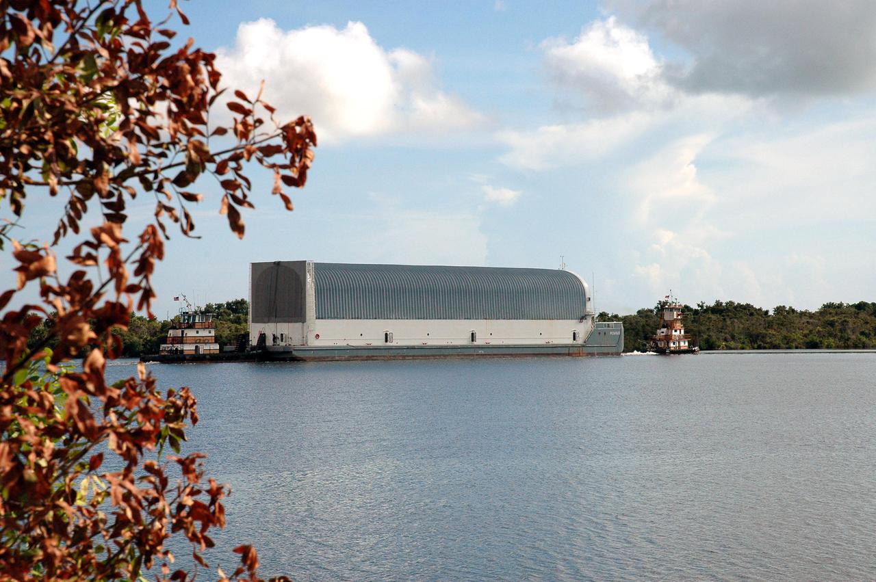 KENNEDY SPACE CENTER, FLA. - Viewed across the Turn Basin at NASA Kennedy Space Center, the barge Pegasus is towed away from the dock on the other side. It is being towed to Port Canaveral where it will join one of the Solid Rocket Booster Recovery Ships and begin its journey around the Florida peninsula to Michoud Assembly Facility in New Orleans. The barge’s cargo is External Tank 119. Delivered to KSC in June, ET-119 is the third newly redesigned tank.