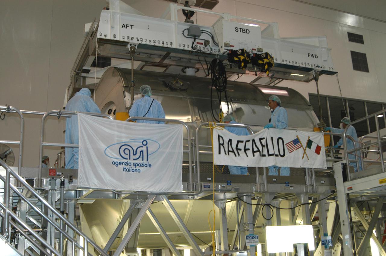 KENNEDY SPACE CENTER, FLA. -- In the Space Station Processing Facility, the suspended Multi-Purpose Logistics Module Raffaello rests on its work stand.  The module will be emptied of its contents, returned from the International Space Station on mission STS-114. During the Return to Flight mission STS-114, the crews of Discovery and Expedition 11 transferred more than a ton of material from the ISS to be returned to Earth.
