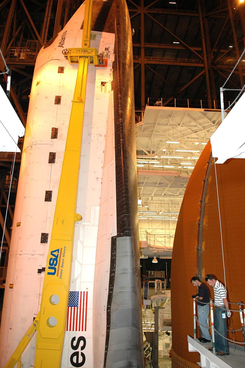 KENNEDY SPACE CENTER, FLA.  - In the Vehicle Assembly Building, technicians spot for Space Shuttle Atlantis as it is demated from its External Tank_Solid Rocket Booster stack. The orbiter will be lowered into the transfer aisle and rolled back to Orbiter Processing Facility (OPF) bay 1. Once in the OPF, processing will begin for mission STS-115, the 19th flight to the International Space Station. The tank, ET-120, is the first redesigned ET to arrive at KSC and will undergo further testing before Return to Flight mission STS-121 next year.