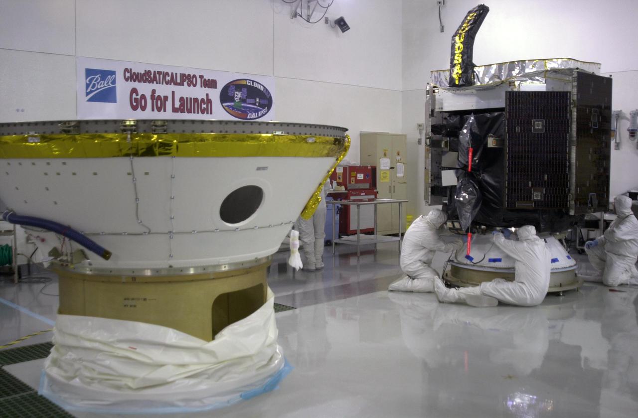 KENNEDY SPACE CENTER, FLA.  - In a clean room at Vandenberg Air Force Base in California, workers prepare NASA's CloudSat spacecraft (right) that will be fitted inside the lower portion of the Delta Payload Attach Fitting at left.  CloudSat joins the CALIPSO spacecraft for launch.  CALIPSO stands for Cloud-Aerosol Lidar and Infrared Pathfinder Satellite Observation. CALIPSO and CloudSat are highly complementary satellites that will provide never-before-seen 3-D perspectives of how clouds and aerosols form, evolve, and affect weather and climate. CALIPSO and CloudSat will fly in formation with three other satellites in the A-train constellation to enhance understanding of our climate system. Launch of CALIPSO_CloudSat aboard a Boeing Delta II rocket is scheduled for 3:01 a.m. PDT Sept. 29.