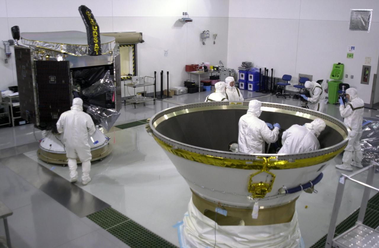KENNEDY SPACE CENTER, FLA.  - In a clean room at Vandenberg Air Force Base in California, workers prepare the inside of the lower portion of the Delta Payload Attach Fitting (right) for the installation of NASA's CloudSat spacecraft (left). CloudSat joins the CALIPSO spacecraft for launch.  CALIPSO stands for Cloud-Aerosol Lidar and Infrared Pathfinder Satellite Observation. CALIPSO and CloudSat are highly complementary satellites that will provide never-before-seen 3-D perspectives of how clouds and aerosols form, evolve, and affect weather and climate. CALIPSO and CloudSat will fly in formation with three other satellites in the A-train constellation to enhance understanding of our climate system. Launch of CALIPSO_CloudSat aboard a Boeing Delta II rocket is scheduled for 3:01 a.m. PDT Sept. 29.