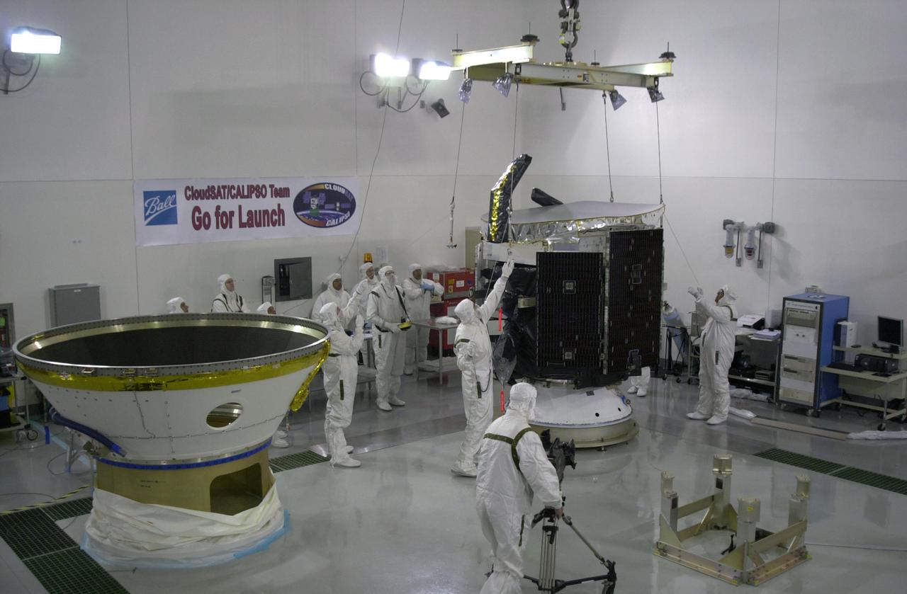 KENNEDY SPACE CENTER, FLA.  - In a clean room at Vandenberg Air Force Base in California, at right, a crane is attached to NASA's CloudSat spacecraft.  CloudSat is being moved for installation into the lower portion of the Delta Payload Attach Fitting at left.      CloudSat joins the CALIPSO spacecraft for launch.  CALIPSO stands for Cloud-Aerosol Lidar and Infrared Pathfinder Satellite Observation. CALIPSO and CloudSat are highly complementary satellites that will provide never-before-seen 3-D perspectives of how clouds and aerosols form, evolve, and affect weather and climate. CALIPSO and CloudSat will fly in formation with three other satellites in the A-train constellation to enhance understanding of our climate system. Launch of CALIPSO_CloudSat aboard a Boeing Delta II rocket is scheduled for 3:01 a.m. PDT Sept. 29.