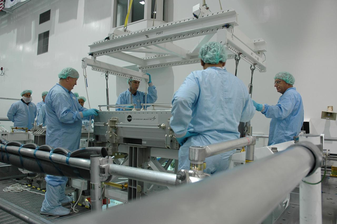 KENNEDY SPACE CENTER, FLA. - In the Space Station Processing Facility, workers prepare to lift the tile box from the Lightweight Multi-Purpose Experiment Support Structure Carrier (LMC) that was returned on Space Shuttle Discovery from mission STS-114. The tile box is the Detailed Test Objective (DTO) tile sample repair kit that astronauts experimented with on the mission. The box is being returned to Johnson Space Center in Houston.