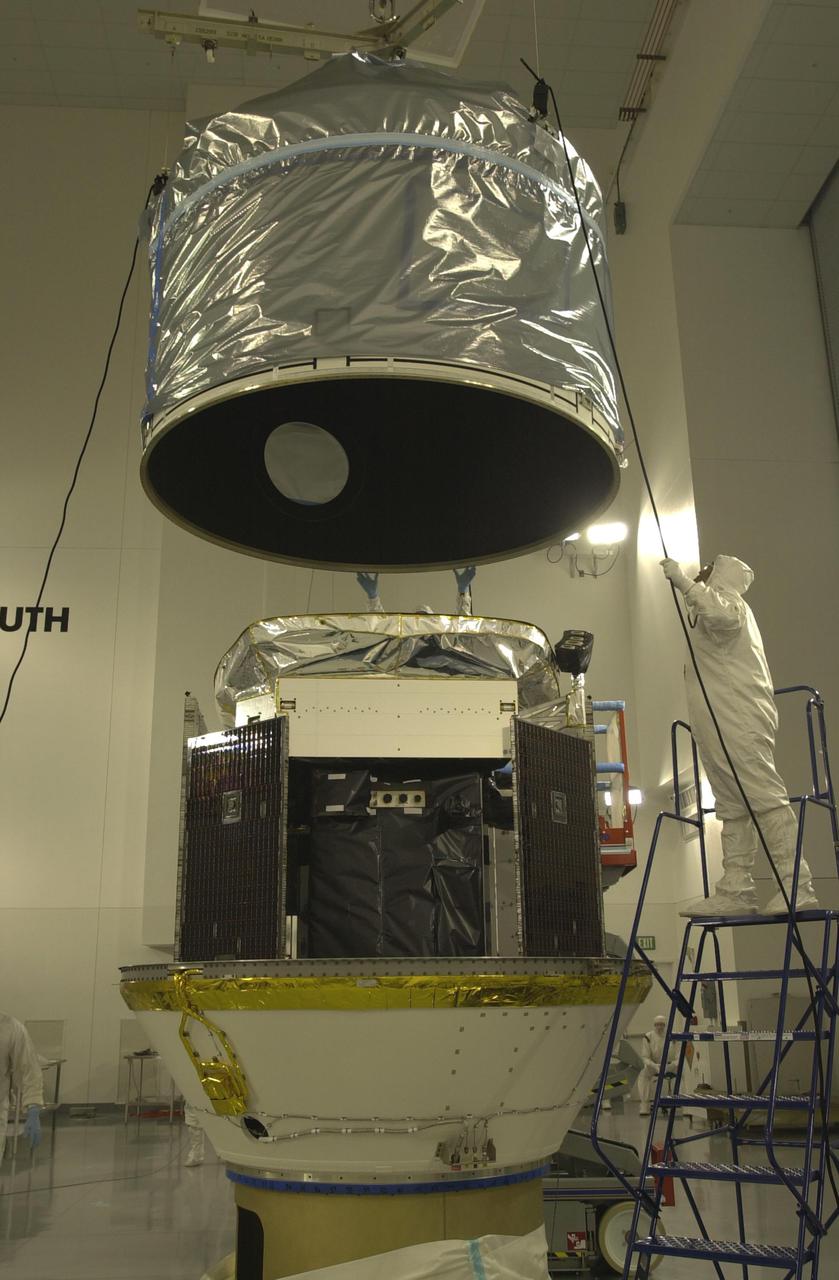 VANDENBERG AIR FORCE BASE, CALIF. - Inside the Astrotech Payload Processing Facility on Vandenberg Air Force Base in California, the upper Delta Payload Attach Fitting (UDPAF) is lowered toward the lower Delta Payload Attach Fitting (LDPAF) at right. The UDPAF will hold the CALIPSO satellite and the LDPAF holds the CloudSat satellite. The two sections will be mated. CALIPSO stands for Cloud-Aerosol Lidar and Infrared Pathfinder Satellite Observation. CALIPSO and CloudSat are highly complementary satellites that will provide never-before-seen 3-D perspectives of how clouds and aerosols form, evolve, and affect weather and climate. CALIPSO and CloudSat will fly in formation with three other satellites in the A-train constellation to enhance understanding of our climate system. Launch of CALIPSO_CloudSat aboard a Boeing Delta II rocket is scheduled for 3:01 a.m. PDT Sept. 29.