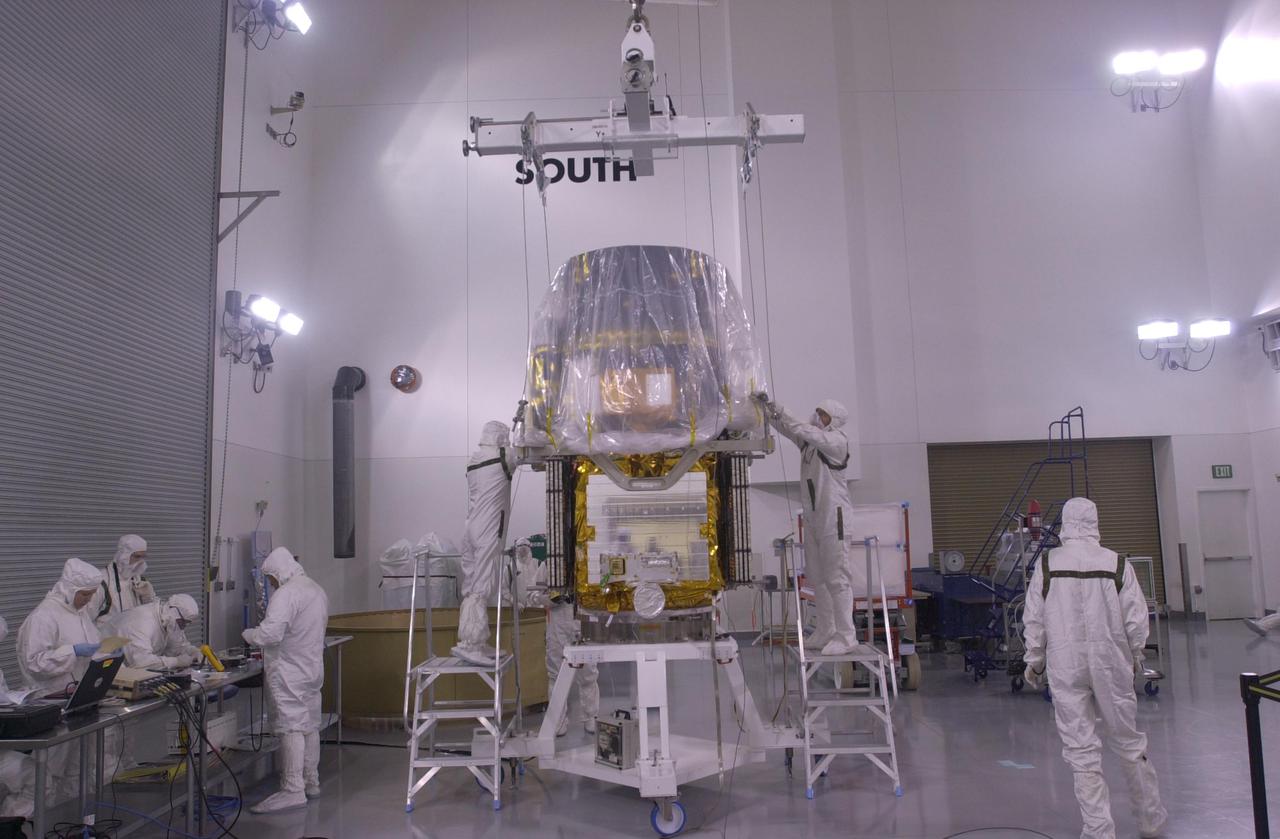 VANDENBERG AIR FORCE BASE, CALIF. —  Inside the Astrotech Payload Processing Facility on Vandenberg Air Force Base in California, workers attach an overhead crane to the CALIPSO spacecraft.  CALIPSO will be lifted and attached to the upper Delta Payload Attach Fitting (UDPAF).   Later the UDPAF will be mated with the lower Delta Payload Attach Fitting, which contains the CloudSat satellite.  The PAF is the interface between the spacecraft and the second stage of the rocket.  CALIPSO stands for Cloud-Aerosol Lidar and Infrared Pathfinder Satellite Observation. CALIPSO and CloudSat are highly complementary satellites that will provide never-before-seen 3-D perspectives of how clouds and aerosols form, evolve, and affect weather and climate. CALIPSO and CloudSat will fly in formation with three other satellites in the A-train constellation to enhance understanding of our climate system. Launch of CALIPSO_CloudSat aboard a Boeing Delta II rocket is scheduled for 3:01 a.m. PDT Sept. 29.