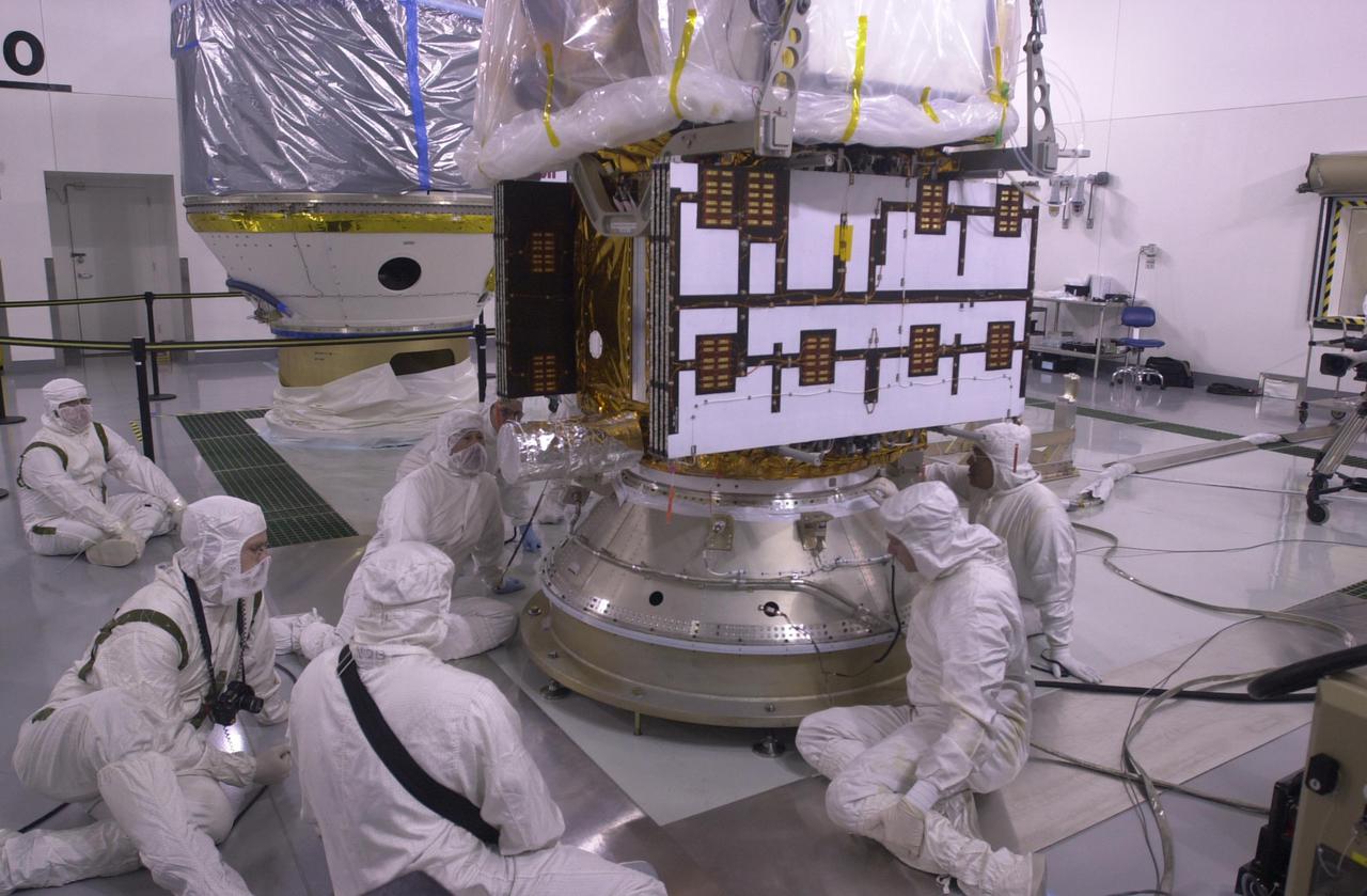 VANDENBERG AIR FORCE BASE, CALIF. —  Inside the Astrotech Payload Processing Facility on Vandenberg Air Force Base in California, workers help secure the CALIPSO spacecraft to the upper Delta Payload Attach Fitting (UDPAF).  Later the UDPAF will be mated with the lower Delta Payload Attach Fitting, which contains the CloudSat satellite.  The PAF is the interface between the spacecraft and the second stage of the rocket.  CALIPSO stands for Cloud-Aerosol Lidar and Infrared Pathfinder Satellite Observation. CALIPSO and CloudSat are highly complementary satellites that will provide never-before-seen 3-D perspectives of how clouds and aerosols form, evolve, and affect weather and climate. CALIPSO and CloudSat will fly in formation with three other satellites in the A-train constellation to enhance understanding of our climate system. Launch of CALIPSO_CloudSat aboard a Boeing Delta II rocket is scheduled for 3:01 a.m. PDT Sept. 29.