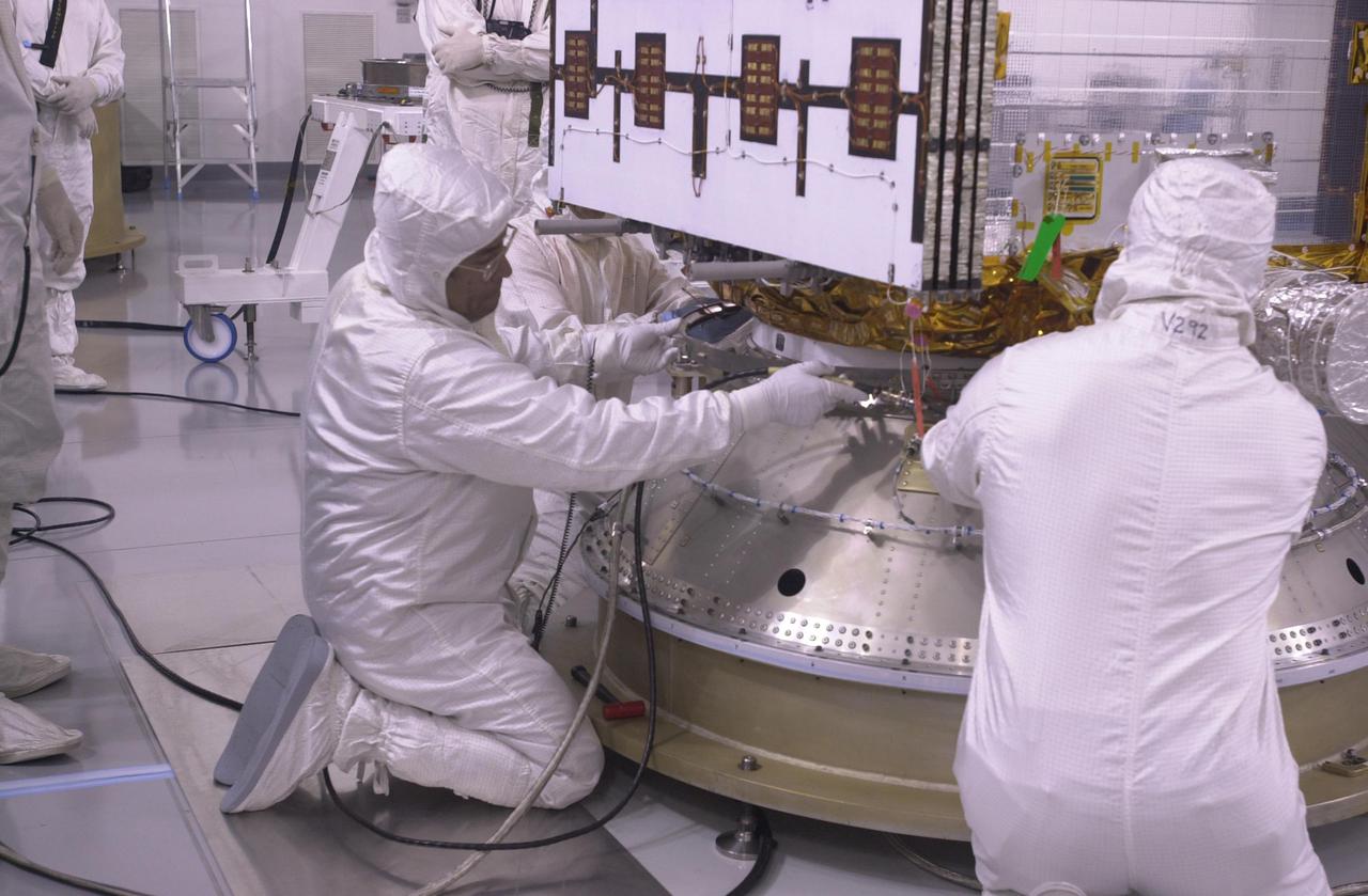 VANDENBERG AIR FORCE BASE, CALIF. — Inside the Astrotech Payload Processing Facility on Vandenberg Air Force Base in California, workers attach the CALIPSO spacecraft to the upper Delta Payload Attach Fitting (UDPAF).   Later the UDPAF will be mated with the lower Delta Payload Attach Fitting, which contains the CloudSat satellite.  The PAF is the interface between the spacecraft and the second stage of the rocket.  CALIPSO stands for Cloud-Aerosol Lidar and Infrared Pathfinder Satellite Observation. CALIPSO and CloudSat are highly complementary satellites that will provide never-before-seen 3-D perspectives of how clouds and aerosols form, evolve, and affect weather and climate. CALIPSO and CloudSat will fly in formation with three other satellites in the A-train constellation to enhance understanding of our climate system. Launch of CALIPSO_CloudSat aboard a Boeing Delta II rocket is scheduled for 3:01 a.m. PDT Sept. 29.