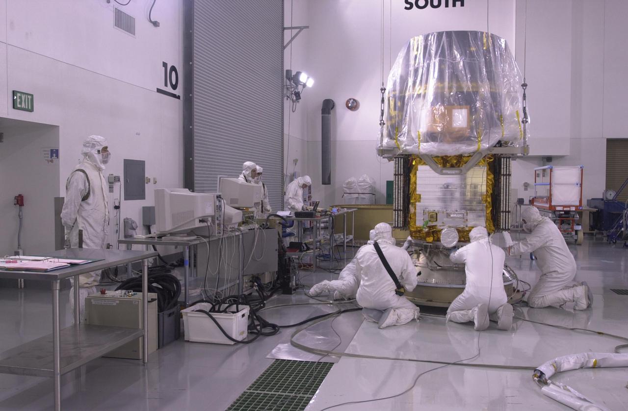 VANDENBERG AIR FORCE BASE, CALIF. — Inside the Astrotech Payload Processing Facility on Vandenberg Air Force Base in California, workers attach the CALIPSO spacecraft to the upper Delta Payload Attach Fitting (UDPAF).  Later the UDPAF will be mated with the lower Delta Payload Attach Fitting, which contains the CloudSat satellite.  The PAF is the interface between the spacecraft and the second stage of the rocket.  CALIPSO stands for Cloud-Aerosol Lidar and Infrared Pathfinder Satellite Observation. CALIPSO and CloudSat are highly complementary satellites that will provide never-before-seen 3-D perspectives of how clouds and aerosols form, evolve, and affect weather and climate. CALIPSO and CloudSat will fly in formation with three other satellites in the A-train constellation to enhance understanding of our climate system. Launch of CALIPSO_CloudSat aboard a Boeing Delta II rocket is scheduled for 3:01 a.m. PDT Sept. 29.