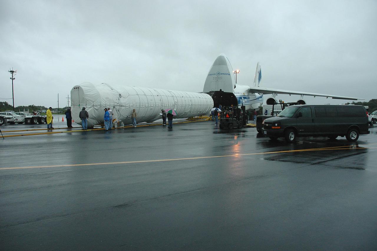 KENNEDY SPACE CENTER, FLA. — At the Cape Canaveral Air Force Station Skid Strip, the first stage of an Atlas V rocket is offloaded from an Atlas V rocket from a Russian air cargo plane. The Atlas V is the launch vehicle for the New Horizons spacecraft. New Horizons is designed to help us understand worlds at the edge of our solar system by making the first reconnaissance of Pluto and Charon - a 'double planet' and the last planet in our solar system to be visited by spacecraft. The mission will then visit one or more objects in the Kuiper Belt region beyond Neptune. New Horizons is scheduled to launch from Launch Complex 41 at CCAFS in January 2006, swing past Jupiter for a gravity boost and scientific studies in February or March 2007, and reach Pluto and its moon, Charon, in July 2015.