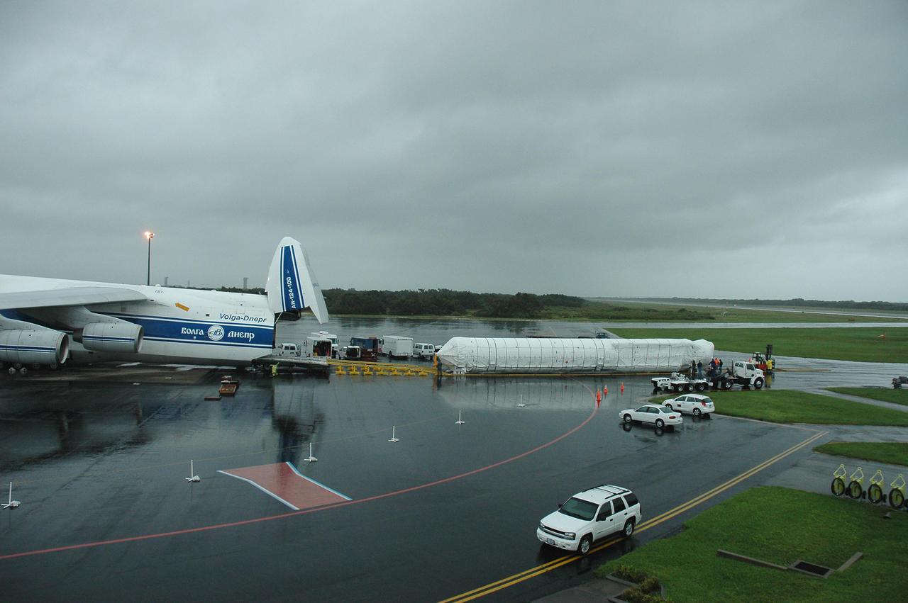 KENNEDY SPACE CENTER, FLA. — At the Cape Canaveral Air Force Station Skid Strip, the first stage of an Atlas V rocket is offloaded from an Atlas V rocket from a Russian air cargo plane. The Atlas V is the launch vehicle for the New Horizons spacecraft. New Horizons is designed to help us understand worlds at the edge of our solar system by making the first reconnaissance of Pluto and Charon - a 'double planet' and the last planet in our solar system to be visited by spacecraft. The mission will then visit one or more objects in the Kuiper Belt region beyond Neptune. New Horizons is scheduled to launch from Launch Complex 41 at CCAFS in January 2006, swing past Jupiter for a gravity boost and scientific studies in February or March 2007, and reach Pluto and its moon, Charon, in July 2015.