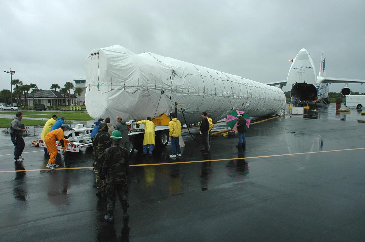 KENNEDY SPACE CENTER, FLA. — At the Cape Canaveral Air Force Station Skid Strip, the first stage of an Atlas V rocket is moved onto a transporter trailer. The rocket is being transferred to the Atlas Space Operations Center. The Atlas V is the launch vehicle for the New Horizons spacecraft. New Horizons is designed to help us understand worlds at the edge of our solar system by making the first reconnaissance of Pluto and Charon - a 'double planet' and the last planet in our solar system to be visited by spacecraft. The mission will then visit one or more objects in the Kuiper Belt region beyond Neptune. New Horizons is scheduled to launch from Launch Complex 41 at CCAFS in January 2006, swing past Jupiter for a gravity boost and scientific studies in February or March 2007, and reach Pluto and its moon, Charon, in July 2015.