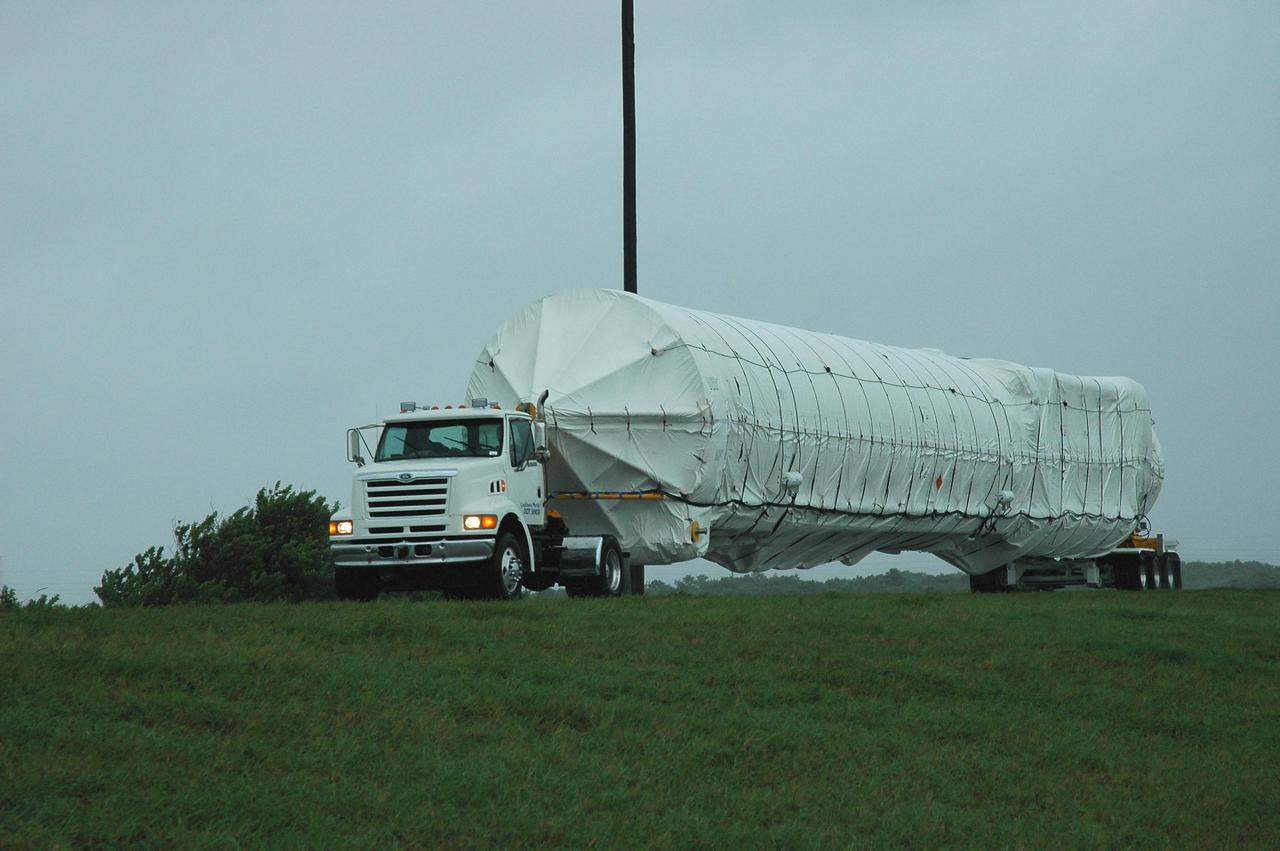 KENNEDY SPACE CENTER, FLA. — A truck carrying an Atlas V rocket heads away from the Cape Canaveral Air Force Station Skid Strip. The rocket is being transferred to the Atlas Space Operations Center. The Atlas V is the launch vehicle for the New Horizons spacecraft. New Horizons is designed to help us understand worlds at the edge of our solar system by making the first reconnaissance of Pluto and Charon - a 'double planet' and the last planet in our solar system to be visited by spacecraft. The mission will then visit one or more objects in the Kuiper Belt region beyond Neptune. New Horizons is scheduled to launch from Launch Complex 41 at CCAFS in January 2006, swing past Jupiter for a gravity boost and scientific studies in February or March 2007, and reach Pluto and its moon, Charon, in July 2015.
