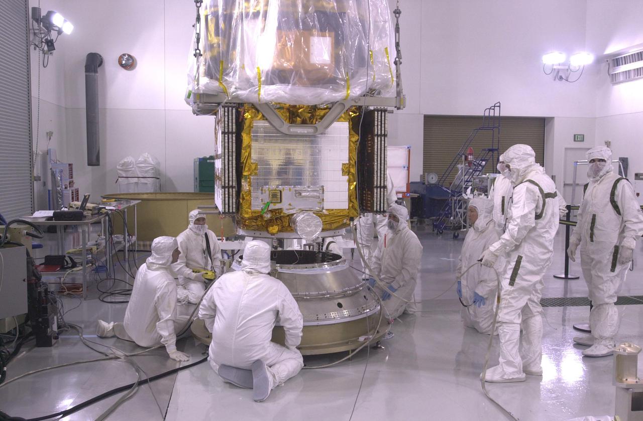 VANDENBERG AIR FORCE BASE, CALIF.  — Inside the Astrotech Payload Processing Facility on Vandenberg Air Force Base in California, workers oversee the lowering of the CALIPSO spacecraft toward the upper Delta Payload Attach Fitting (UDPAF). Later the UDPAF will be mated with the lower Delta Payload Attach Fitting, which contains the CloudSat satellite. The PAF is the interface between the spacecraft and the second stage of the rocket. CALIPSO stands for Cloud-Aerosol Lidar and Infrared Pathfinder Satellite Observation.