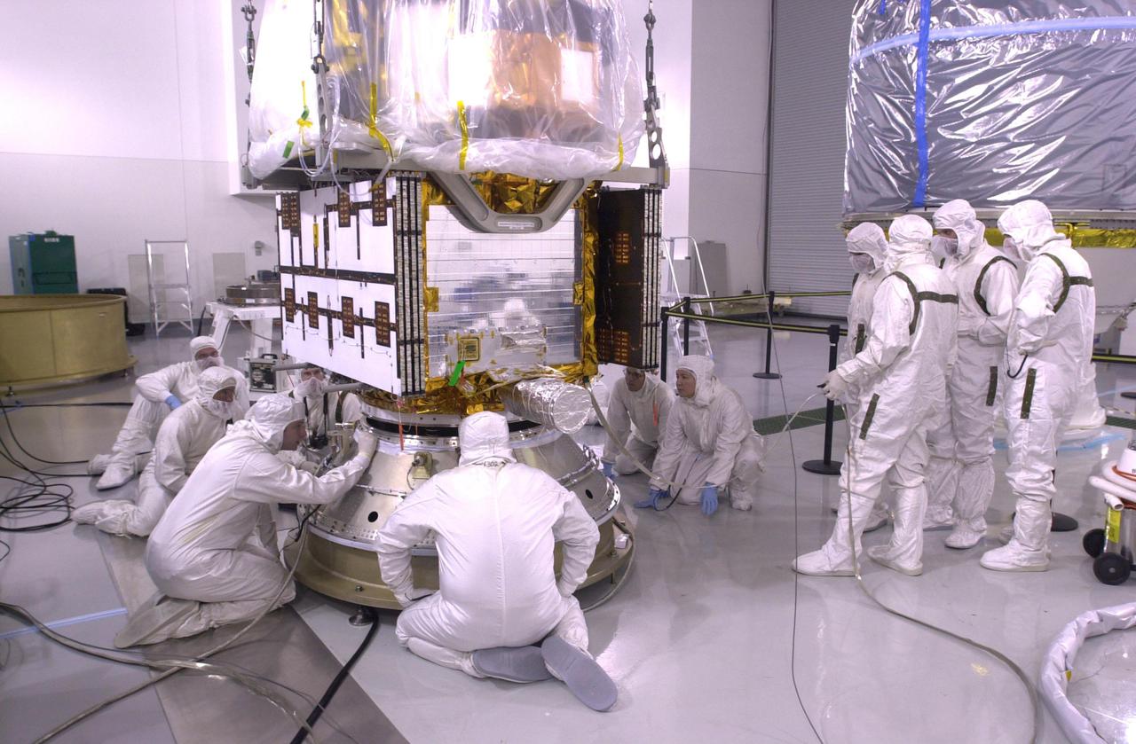 VANDENBERG AIR FORCE BASE, CALIF.  — Inside the Astrotech Payload Processing Facility on Vandenberg Air Force Base in California, workers secure the CALIPSO spacecraft on the upper Delta Payload Attach Fitting (UDPAF).  Later the UDPAF will be mated with the lower Delta Payload Attach Fitting, which contains the CloudSat satellite. The PAF is the interface between the spacecraft and the second stage of the rocket. CALIPSO stands for Cloud-Aerosol Lidar and Infrared Pathfinder Satellite Observation.