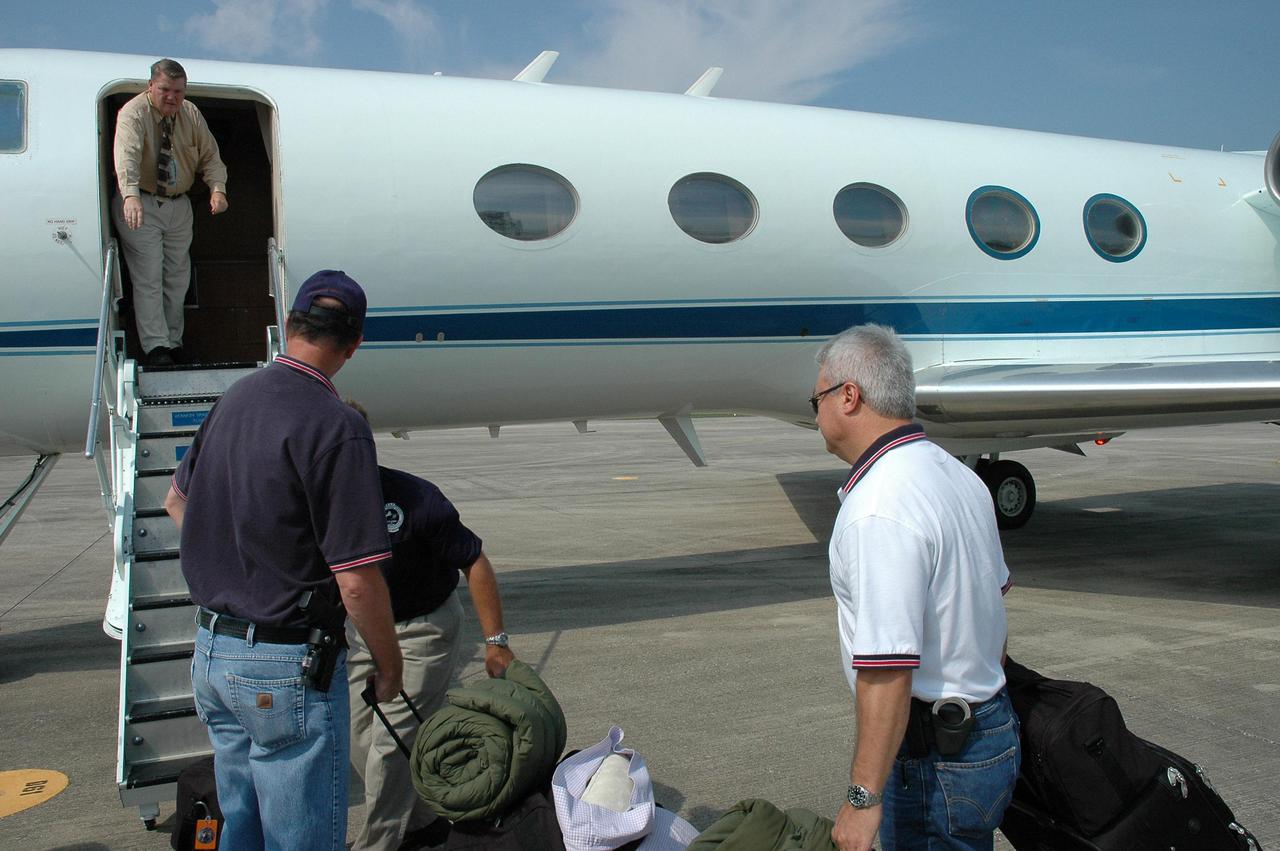 KENNEDY SPACE CENTER, FLA. - At the NASA Kennedy Space Center Shuttle Landing Facility, employees load hurricane relief supplies onto a NASA aircraft bound for Stennis Space Center in Mississippi, which suffered damage from Hurricane Katrina. The two men with backs to the camera are Security personnel going to Stennis to relieve others who have been helping at the center. The supplies included 10 boxes of load bus disconnects going to Michoud Assesmbly Facility near New Orleans and 17 boxes of personal hygiene items, along with boxes of clothing and water. Many Stennis and Michoud employees were rendered homeless by the hurricane. NASA centers have been generous with relief supplies and personnel. Stennis is in limited operations mode. Daily convoys have been moving between Stennis and Michould, transporting personnel and supplies as Michoud prepares to resume limited operations.