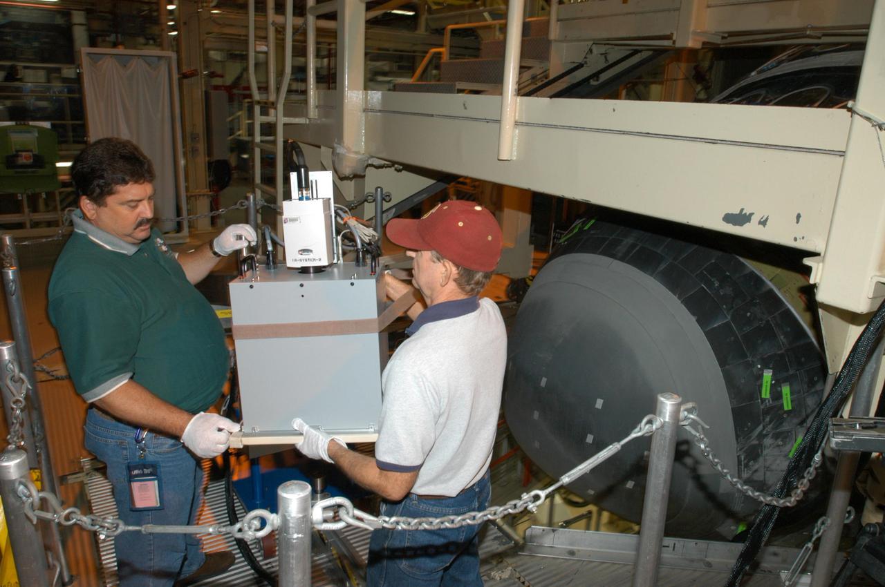 KENNEDY SPACE CENTER, FLA. - In NASA Kennedy Space Center’s Orbiter Processing Facility, bay 3, Don Nielen (left) and Dick Logsdon, both with United Space Alliance, prepare the equipment to be used for thermography of Discovery’s nose cone. Thermography uses high-intensity light to heat specific areas, which are then immediately scanned with an infrared camera. As the area cools, internal flaws are revealed. Discovery has been identified as the orbiter to fly on mission STS-121.