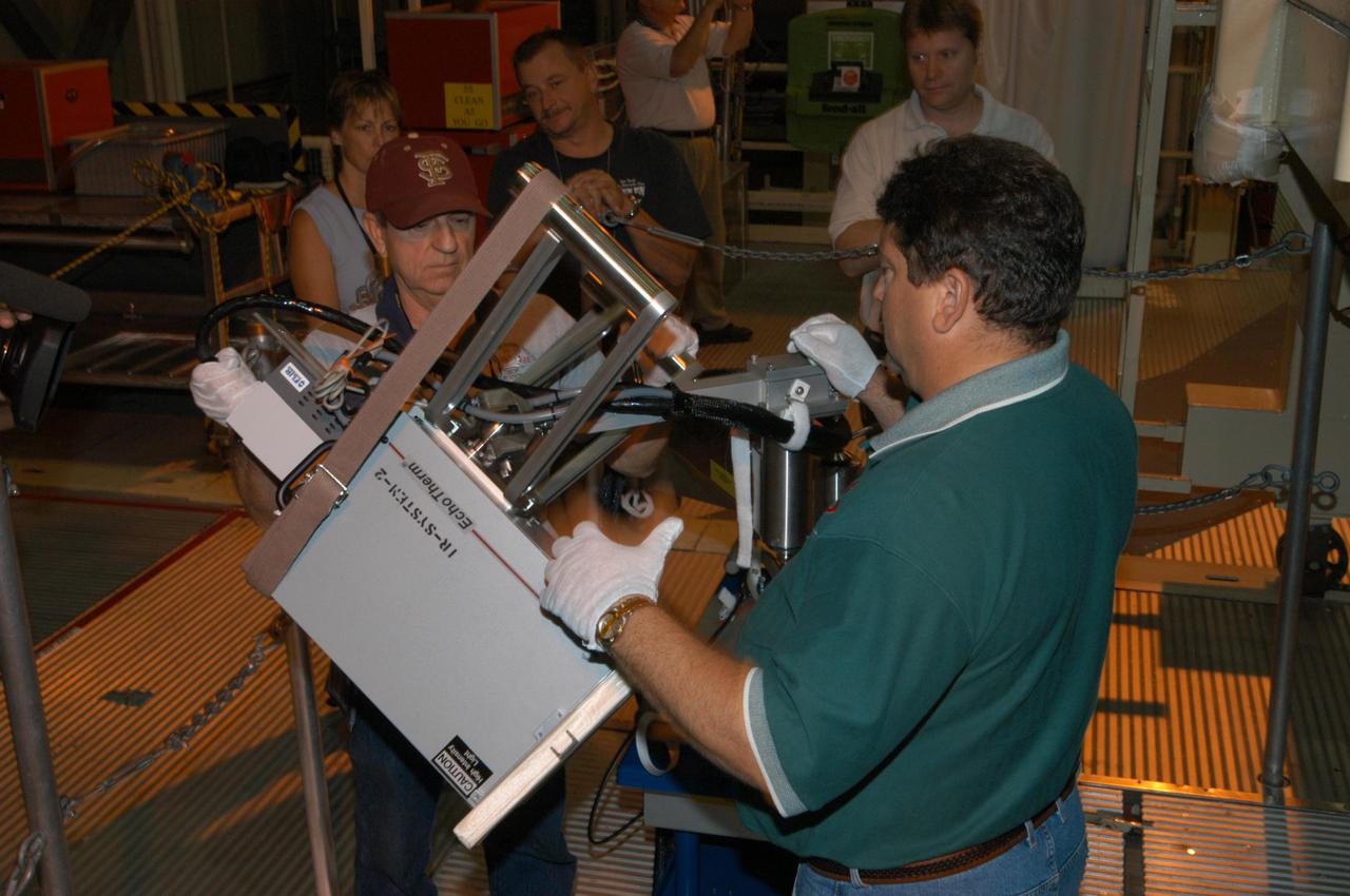 KENNEDY SPACE CENTER, FLA. - In NASA Kennedy Space Center’s Orbiter Processing Facility, bay 3, Don Nielen (foreground), with United Space Alliance, gets help from Dick Logsdon, also with USA, setting up equipment to be used for thermography of Discovery’s nose cone. Thermography uses high-intensity light to heat specific areas, which are then immediately scanned with an infrared camera. As the area cools, internal flaws are revealed. Discovery has been identified as the orbiter to fly on mission STS-121.