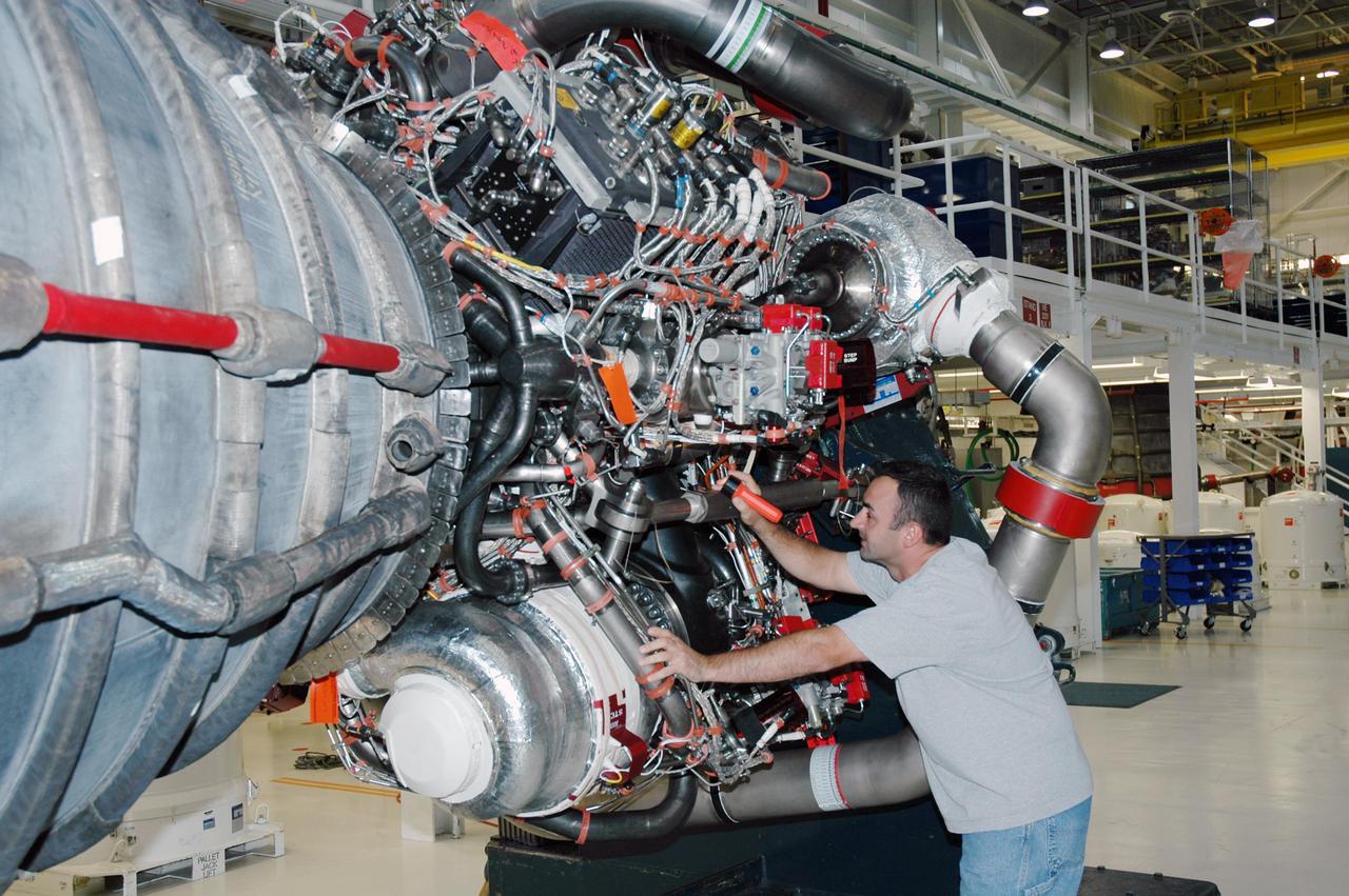 KENNEDY SPACE CENTER, FLA. - In NASA Kennedy Space Center’s Orbiter Processing Facility, bay 3, a worker checks hardware on a space shuttle main engine removed from the orbiter Discovery. The orbiter will be processed for the second Return to Flight mission, STS-121.