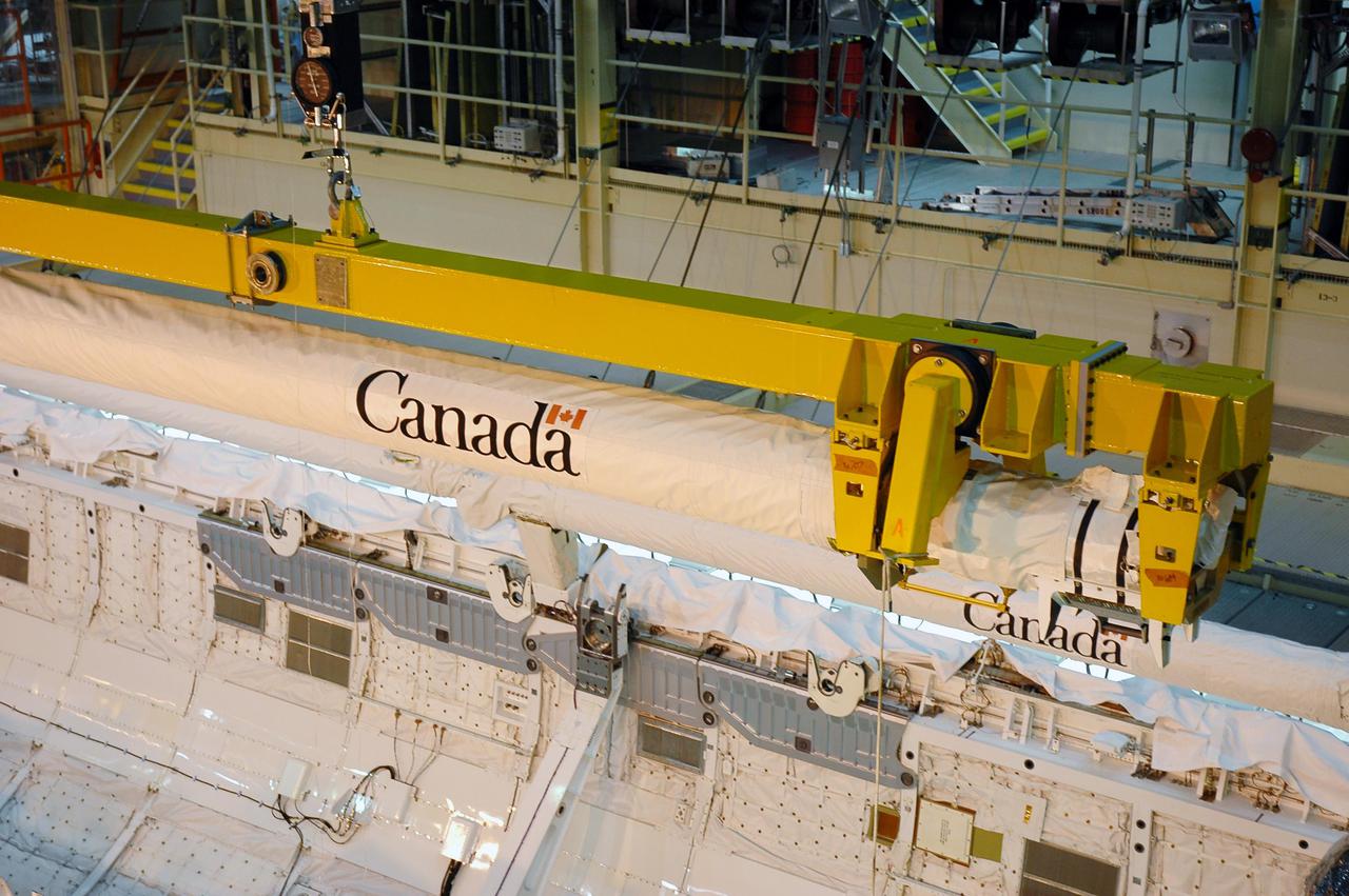 KENNEDY SPACE CENTER, FLA. - In NASA Kennedy Space Center’s Orbiter Processing Facility, bay 3, the Canadian-built orbiter boom sensor system robotic arm is removed from Discovery’s payload bay. The boom, which was was used on Return to Flight mission STS-114 to provide more extensive inspection and photography of Discovery, will undergo inspection. The orbiter will be processed for the second Return to Flight mission, STS-121.