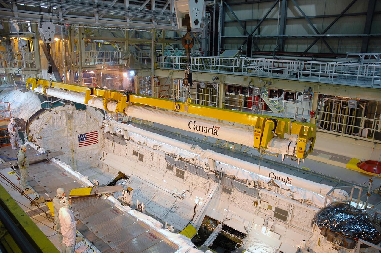 KENNEDY SPACE CENTER, FLA. - In NASA Kennedy Space Center’s Orbiter Processing Facility, bay 3, the Canadian-built orbiter boom sensor system robotic arm is removed from Discovery’s payload bay. The boom, which was was used on Return to Flight mission STS-114 to provide more extensive inspection and photography of Discovery, will undergo inspection. The orbiter will be processed for the second Return to Flight mission, STS-121.