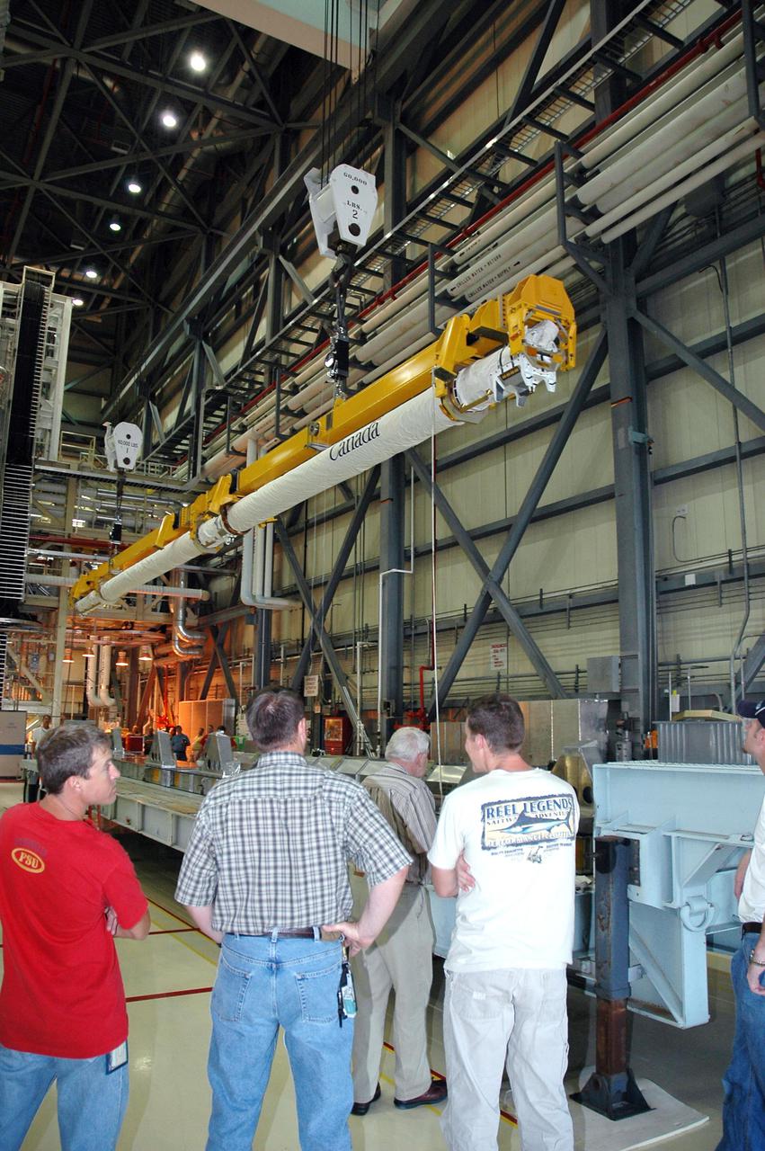 KENNEDY SPACE CENTER, FLA. - In NASA Kennedy Space Center’s Orbiter Processing Facility, bay 3, the Canadian-built orbiter boom sensor system robotic arm is being lowered onto a stand after removal from Discovery’s payload bay. The boom, which was was used on Return to Flight mission STS-114 to provide more extensive inspection and photography of Discovery, will undergo inspection. The orbiter will be processed for the second Return to Flight mission, STS-121.