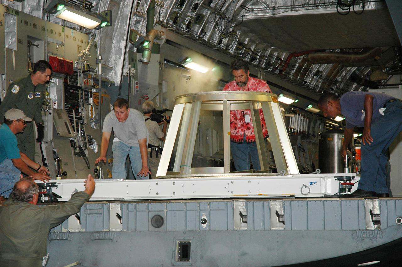KENNEDY SPACE CENTER, FLA. -  At NASA Kennedy Space Center’s Shuttle Landing Facility, workers offload a stand from a U.S. Air Force C-17 cargo plane.  The plane delivered the New Horizons spacecraft and other equipment.  After it is unloaded, the spacecraft will be transported to the Payload Hazardous Servicing Facility. The test stand will hold the spacecraft during checkout.  New Horizons is designed to help us understand worlds at the edge of our solar system by making the first reconnaissance of Pluto and Charon - a 'double planet' and the last planet in our solar system to be visited by spacecraft. The mission will then visit one or more objects in the Kuiper Belt region beyond Neptune. New Horizons is scheduled to launch in January 2006, swing past Jupiter for a gravity boost and scientific studies in February or March 2007, and reach Pluto and its moon, Charon, in July 2015.