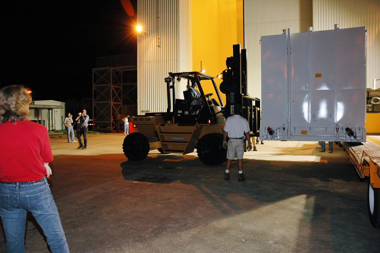 KENNEDY SPACE CENTER, FLA. - At NASA Kennedy Space Center, transporters carrying the New Horizons spacecraft and other equipment arrive at the Payload Hazardous Servicing Facility. New Horizons is designed to help us understand worlds at the edge of our solar system by making the first reconnaissance of Pluto and Charon - a 'double planet' and the last planet in our solar system to be visited by spacecraft. The mission will then visit one or more objects in the Kuiper Belt region beyond Neptune. New Horizons is scheduled to launch in January 2006, swing past Jupiter for a gravity boost and scientific studies in February or March 2007, and reach Pluto and its moon, Charon, in July 2015.