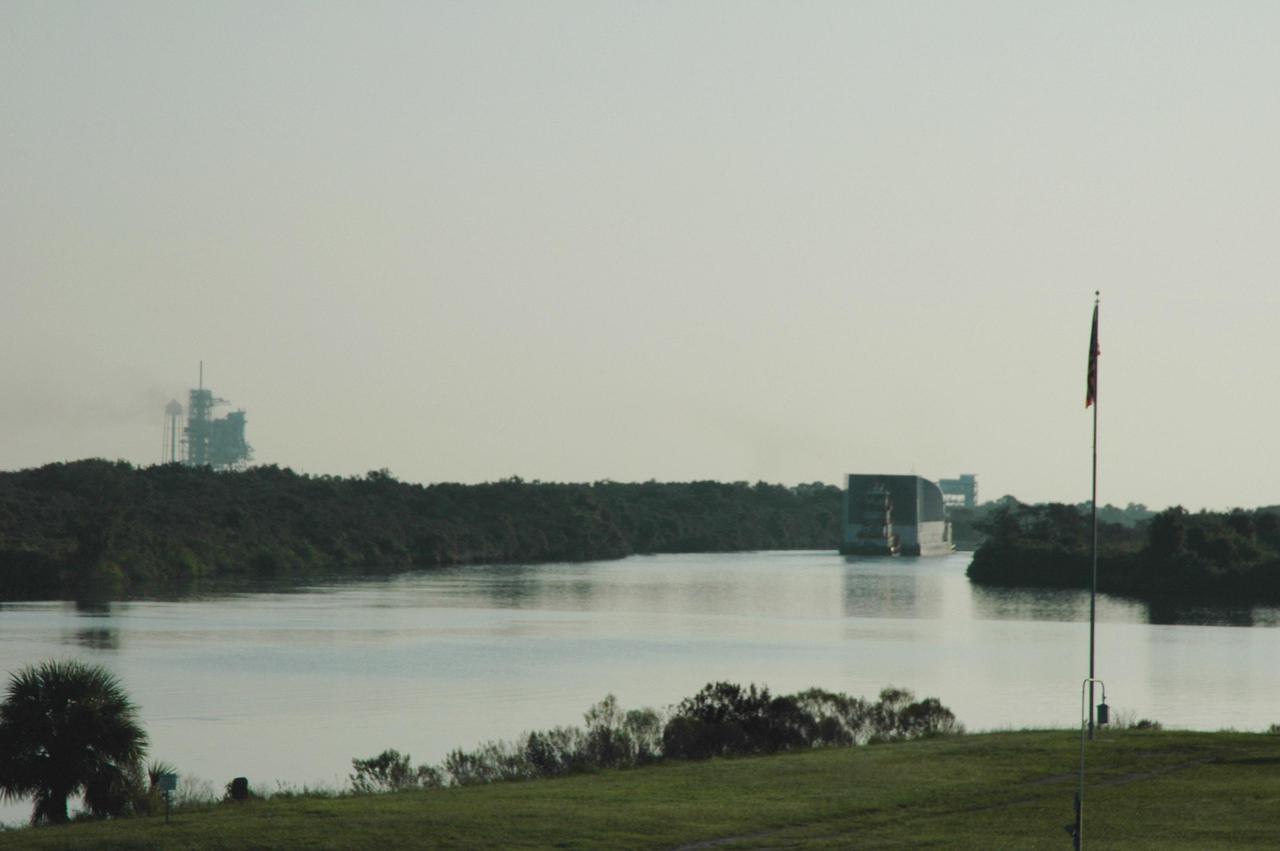 KENNEDY SPACE CENTER, FLA. -   Just after dawn, the Pegasus barge is towed away from the Turn Basin in the Launch Complex 39 area.  The barge is carrying external tank 119 (ET-119) and will be towed by the solid rocket booster retrieval ship Freedom Star  to NASA’s Michoud Assembly Facility near New Orleans.  Delivered to Kennedy in June, ET-119 is the third newly redesigned tank and is the only tank that contains the liquid oxygen heater.  The tank is being returned to Michoud for testing and further modifications.  ET-119 will be the tank used on return to flight mission STS-121.