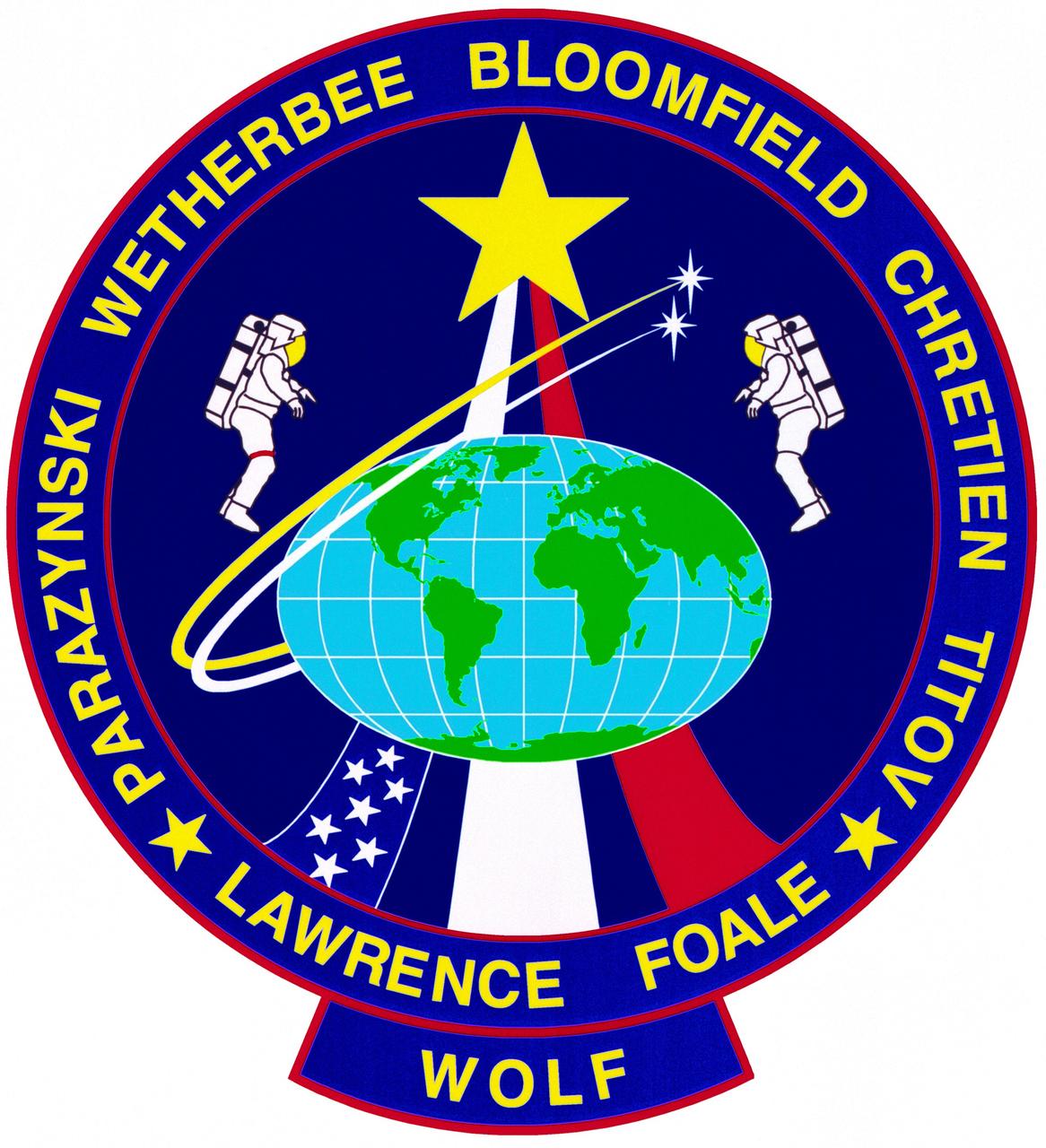 The STS-86 flight was the seventh shuttle-Mir docking mission, symbolized by seven stars. The international crew includes astronauts from the United States, Russia, and France. The flags of these nations are incorporated in the rays of the astronaut logo. The rays of light streaking across the sky depict the orbital tracks of the two spacecraft as they prepare to dock. During the flight, an American astronaut and a Russian cosmonaut will perform an extravehicular activity (EVA). The mercator projection of Earth illustrates the global cooperative nature of the flight. 