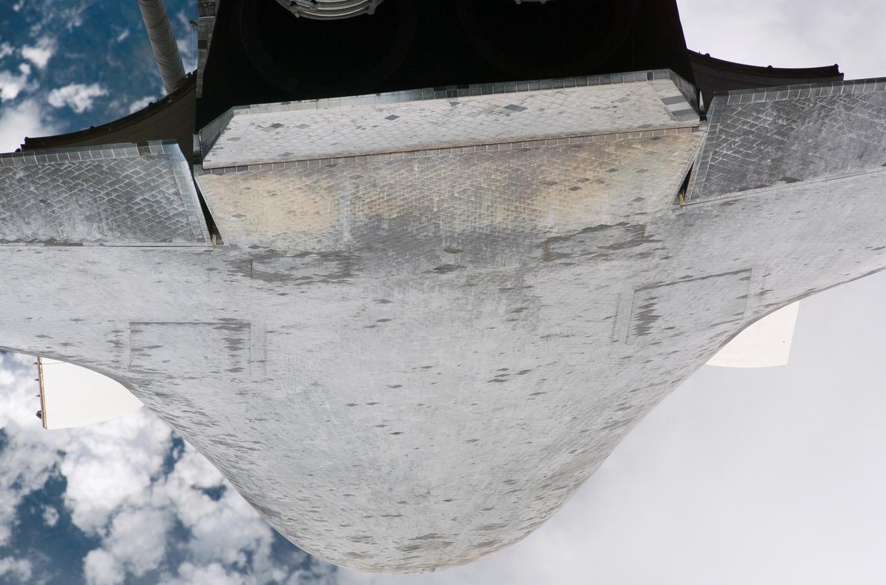 Though very close to the International Space Station, the majority of Discovery's underside is visible in this frame. The image was captured by one of the Expedition 13 crew members onboard the International Space Station (ISS) during the STS-121 Rotating Pitch Maneuver (RPM) survey prior to docking of the two spacecraft.